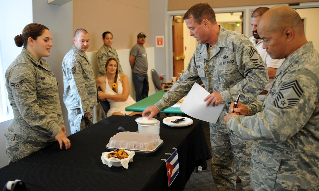 A panel of judges rate Airman 1st Class Gabriela Nunez’s Cuban cuisine during the Around the World Cook-off at the Community Activity Center on Beale Air Force Base, Calif., Aug. 21, 2013. Judges rated food based on taste and appearance. (U.S. Air Force photo by Staff Sgt. Robert M. Trujillo/Released)