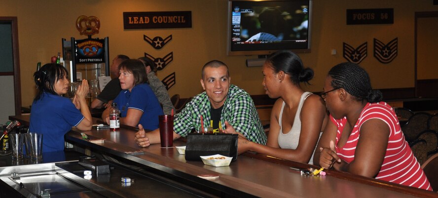 Mibong Dewhurst, left, Club Five Six bartender, observes three role players acting out a sexual harassment scenario Aug. 14 at Club Five Six. The bartenders at Club Five Six received bystander intervention training in an effort to prevent sexual harassment and sexual assault at Luke Air Force Base. (U.S. Air Force photo/Staff Sgt. Luther Mitchell Jr.)