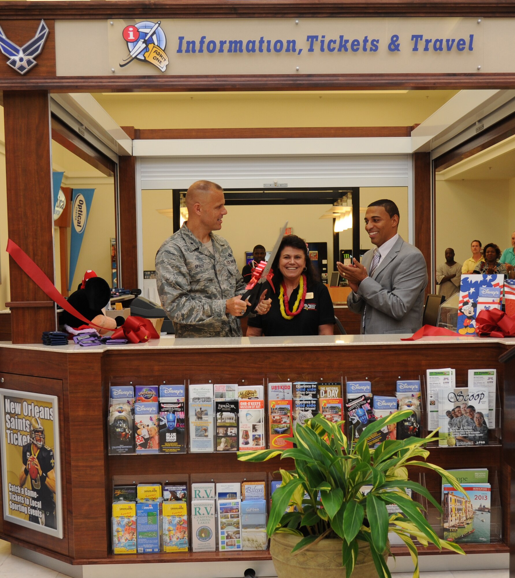 Brig. Gen. Brad Spacy, 81st Training Wing commander; Belinda Kahapea, 81st Force Support Squadron travel consultant, and Greg Hall, base exchange general manager, cut the ribbon during the Information, Tickets and Travel kiosk ribbon cutting ceremony Aug. 22, 2013, at the base exchange, Keesler Air Force Base, Miss. The kiosk is part of a test at six bases for the next year.  (U.S. Air Force photo by Kemberly Groue)
