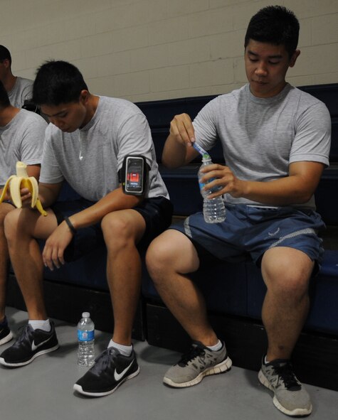 Airman 1st Class Mark Vito, left, 2nd Communications Squadron accountant, eats a banana as Senior Airman Jeffery Sales, 2nd CS airfield systems, adds an electrolyte supplement to his water after a 5K fun-run on Barksdale Air Force Base, La., Aug. 23, 2013. Bananas are a good source of potassium to prevent cramps and electrolytes help to replace fluids in the body that may have been lost during a strenuous workout such as running. (U.S. Air Force photo/Senior Airman Kristin High)