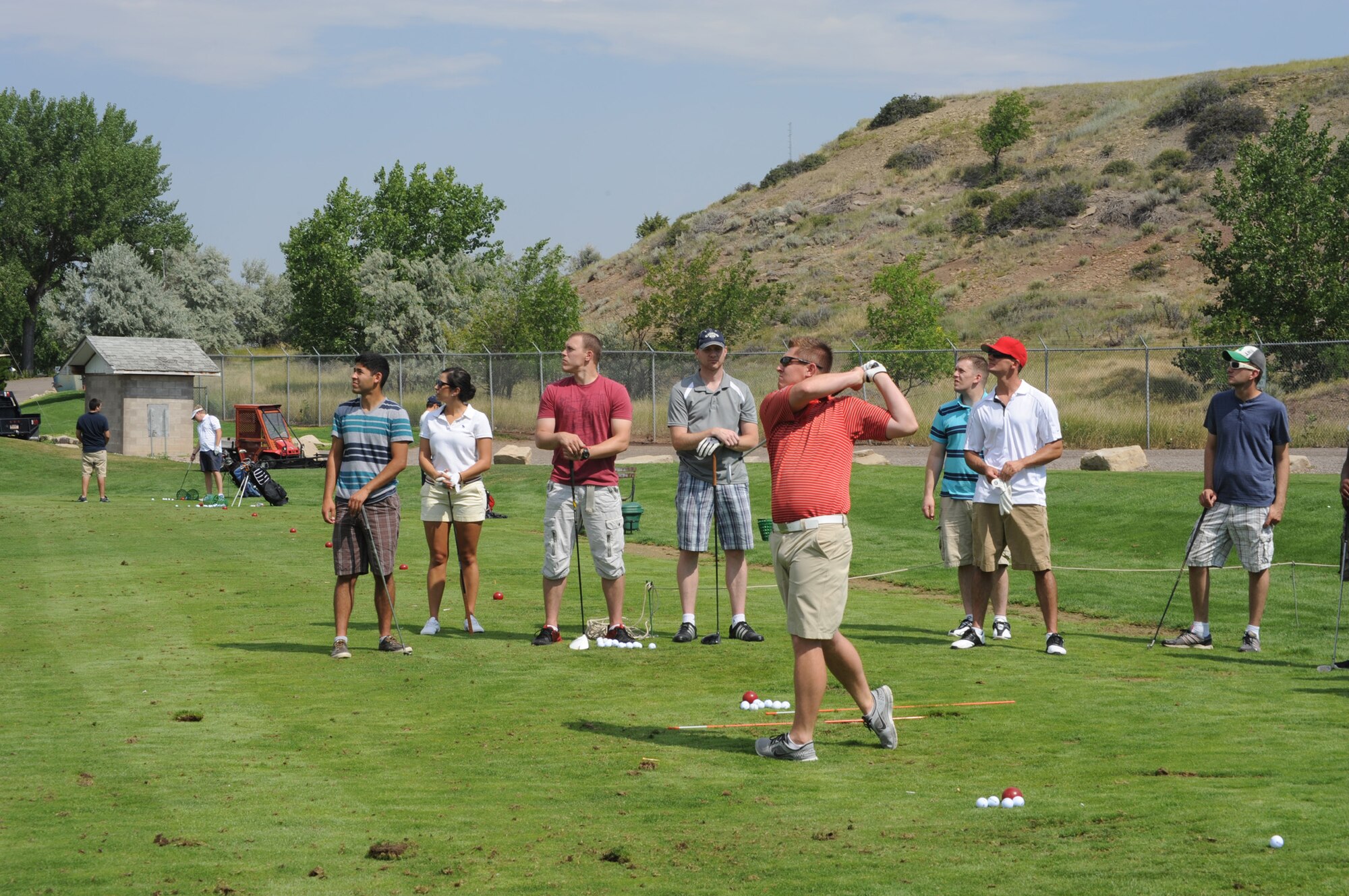 Senior Airman William Nelson, 341st Security Forces Squadron member, teaches Team Malmstrom members how to use proper form while executing a golf swing. During the free golf expo, Airmen were able to use a hands-on approach to learn the basics of the sport.  (U.S. Air Force photo/ Airman 1st Class Collin Schmidt)
