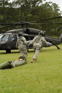 U.S. Army CW-4 Anna Jones, 1-228 Aviation battalion standardization pilot (right), and U.S. Army Sgt. Donique Kirk, 1-228 AB flight medic (left), drag a more than 150 pound mannequin on a skid to a 1-228 UH-60 medical evacuation helicopter Aug. 21, 2013. The purpose of the exercise is to train and validate JTF-B personnel and Honduran Response Force on aircraft accident response procedures by conducting a simulated aircraft accident. (Photo released by U.S. Air Force Staff Sgt. Jarrod Chavana)