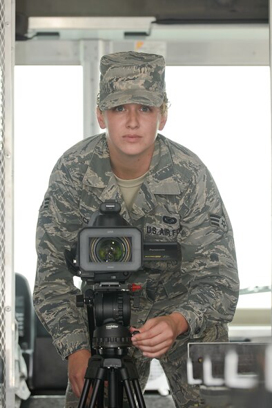 Senior Airman Laura Beckley, a broadcaster currently assigned to Air Force Mortuary Affairs Operations, Dover Air Force Base, Del., sets up her video camera inside the vehicle used to transfer remains to the mortuary Aug. 22, 2013. Beckley is deployed to the mortuary from the 6th Air Mobility Wing, MacDill AFB, Fla. She documents various aspects of the dignified transfer mission for the Department of Defense and families of the fallen. (U.S. Air Force photo/Greg L. Davis)