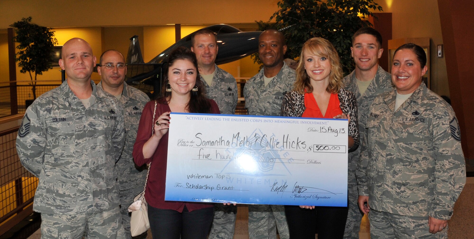 Samantha Melby, left, and Callie Hicks, are presented with the Whiteman Top Three award at Whiteman Air Force Base, Mo., Aug 15, 2013. Samantha, wife of Tech. Sgt. Peter Melby from the 442nd Maintenance Squadron, was recognized for her involvement in her church, community, a band and honor society. Callie, wife of Senior Airman Spenser Hicks from the 509th Civil Engineer Squadron, was recognized for maintaining a 4.0 GPA while studying to get her bachelor’s degree in dietetics. (U.S Air Force photo by Airman 1st Class Keenan Berry/Released)
