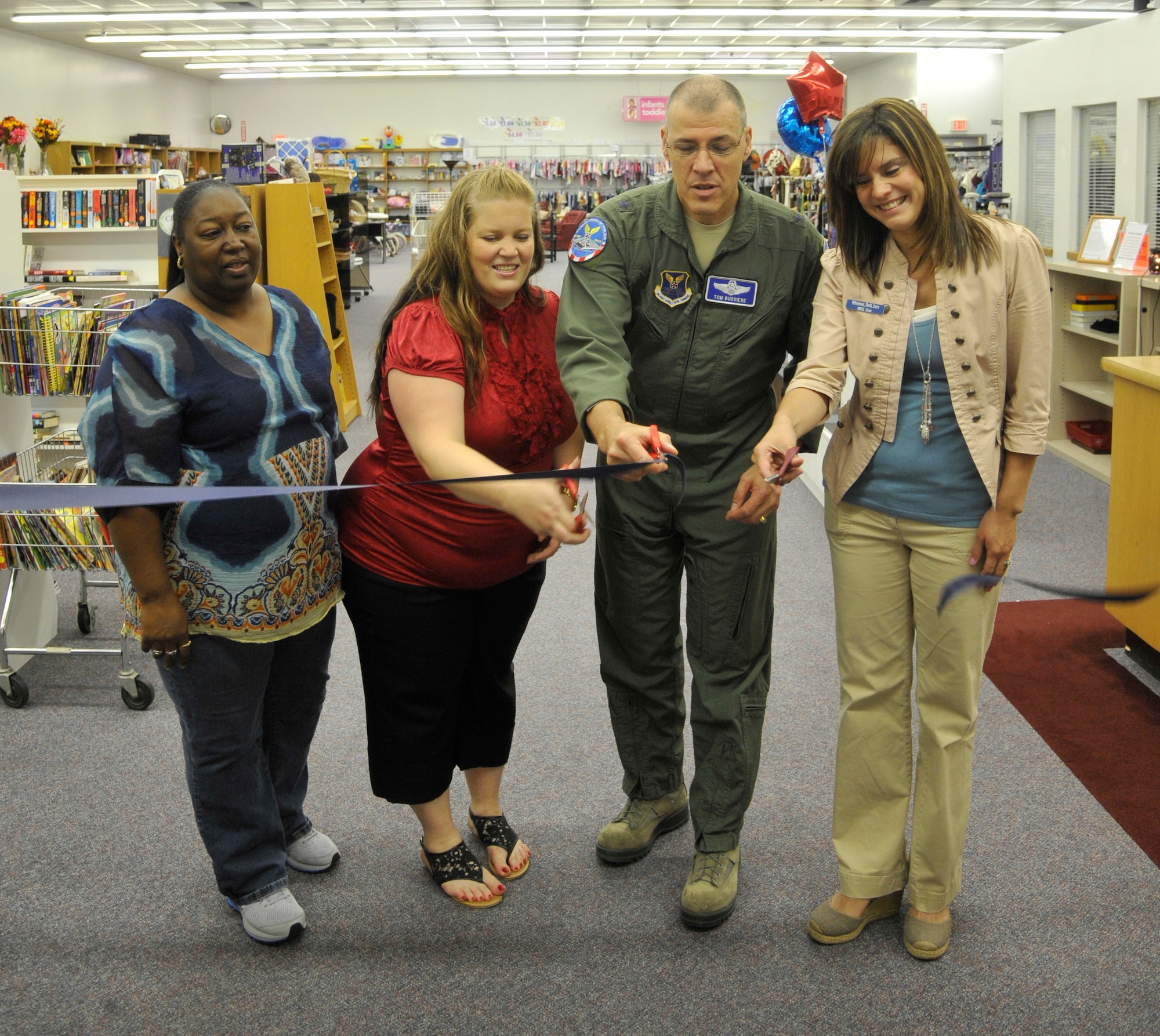 Barbara Barr, Whiteman Enlisted Spouses Club, left, Melissa Aaserude, thrift store volunteer Brig. Gen. Thomas Bussiere, 509th Bomb Wing commander, and Julie Melendez, Whiteman Officers Spouses Club, cut the ribbon for the Whiteman Thrift Store grand opening at Whiteman Air Force Base, Mo., Aug. 16, 2013. The Thrift Store is open Tuesdays and Thursdays from 10 a.m. to 2 p.m. To volunteer, call 660-563-3910. (U.S. Air Force photo by Airman 1st Class Keenan Berry/Released)