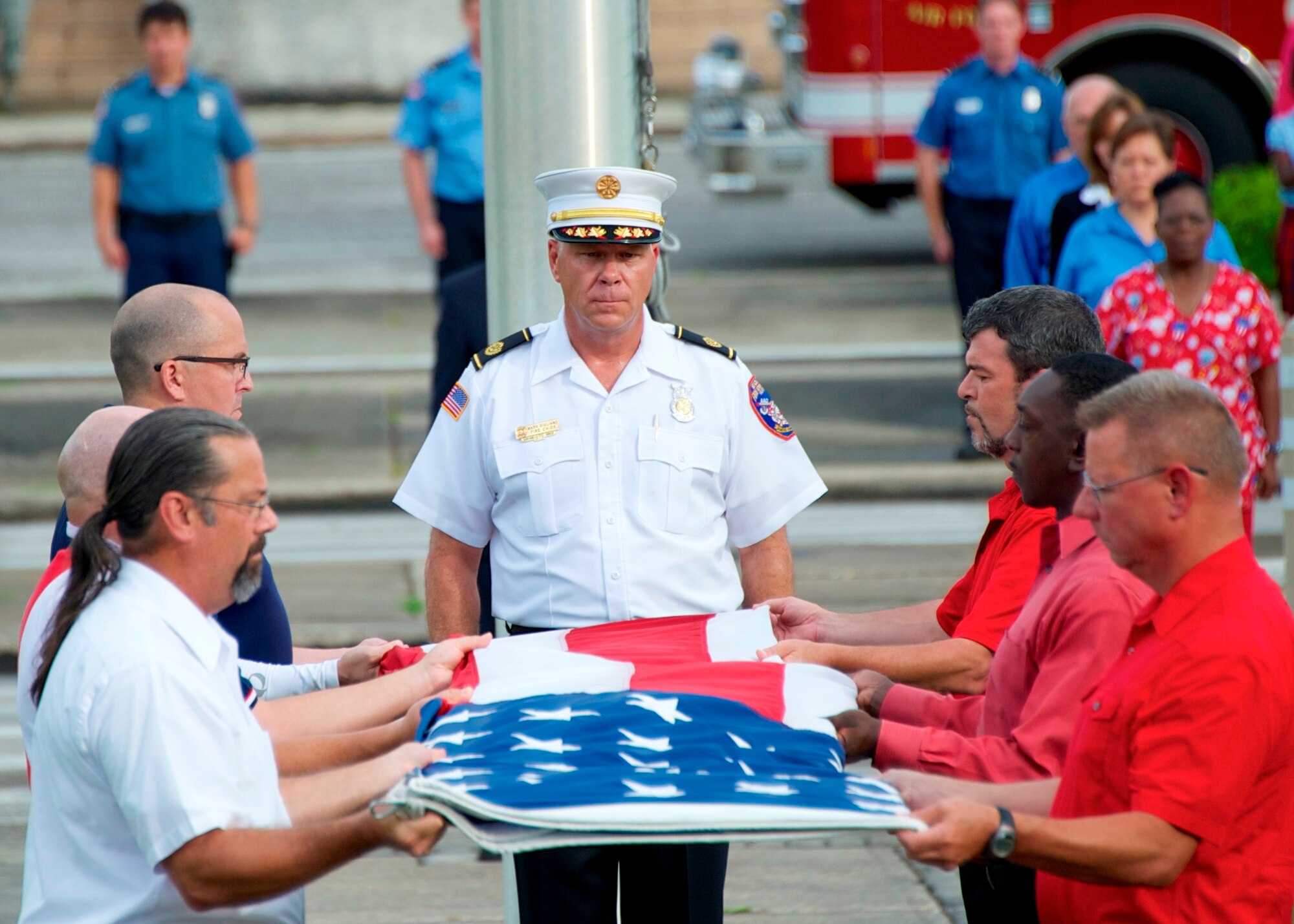 An all-civilian flag detail, led by Fire Chief Mark Giuliano, folds the colors during an Eglin retreat ceremony Aug. 22.  It was the first time the flights and flag detail performing the ceremony were made up of all civilians who presented the colors to Brig. Gen. David Harris, 96th Test Wing commander. Organizers of the event sought at least 35 patriotic Americans ready to stand up for their nation and they met their quota.  (U.S. Air Force photo/Sara Vidoni)