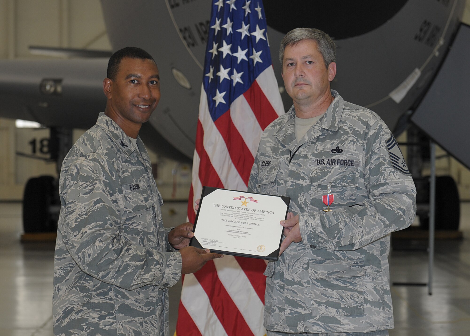 Col. Eric Faison, 22nd Maintenance Group commander, presents Chief Master Sgt. Mark Clegg, 22nd Maintenance Squadron superintendent, a Bronze Star Medal Aug. 16, 2013, at McConnell Air Force Base, Kan. The 376th Air Expeditionary Wing generated more than 3,926 sorties and 14,120 combat flying hours, off-loading over 222 million pounds of fuel to 16,400 Coalition receivers during his deployment. His efforts contributed to the execution of 63 named operations, including Operations Eagle Hammer and Rock Legacy, which led to 134 enemy personnel being killed or detained. (U.S. Air Force photo/Senior Airman Katrina M. Brisbin)