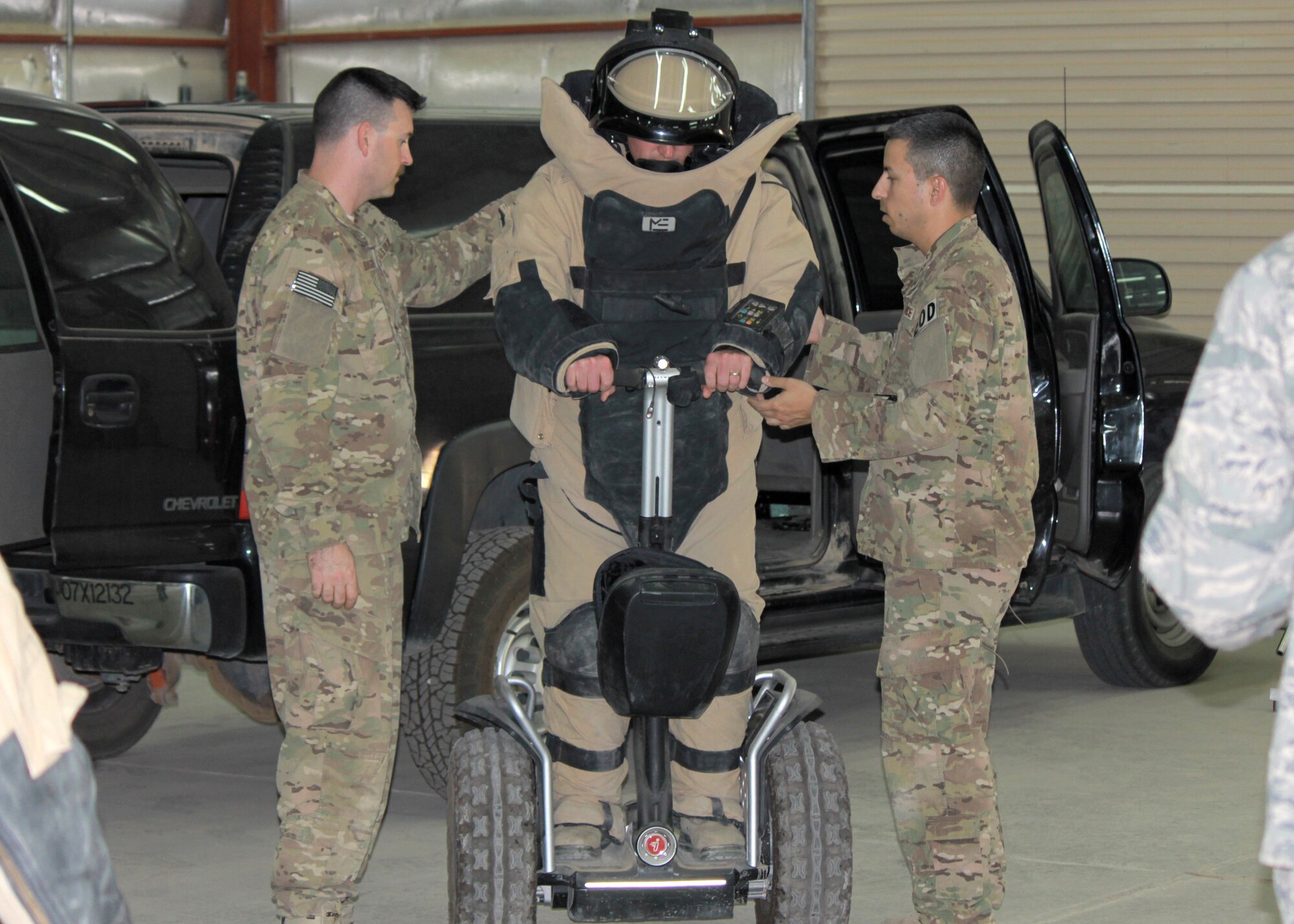 Explosive ordinance disposal Airmen offer assistance as an Airman attempts to operate a Segway while wearing an EOD bomb suit at the 64th Air Expeditionary Group in Southwest Asia, July 26, 2013. The 64th AEG EOD team hosted a two-day open house allowing 64th AEG Airmen an opportunity to learn about their operations and equipment.  (U.S Air Force photo/Staff Sgt. Minerva H. Rosario)