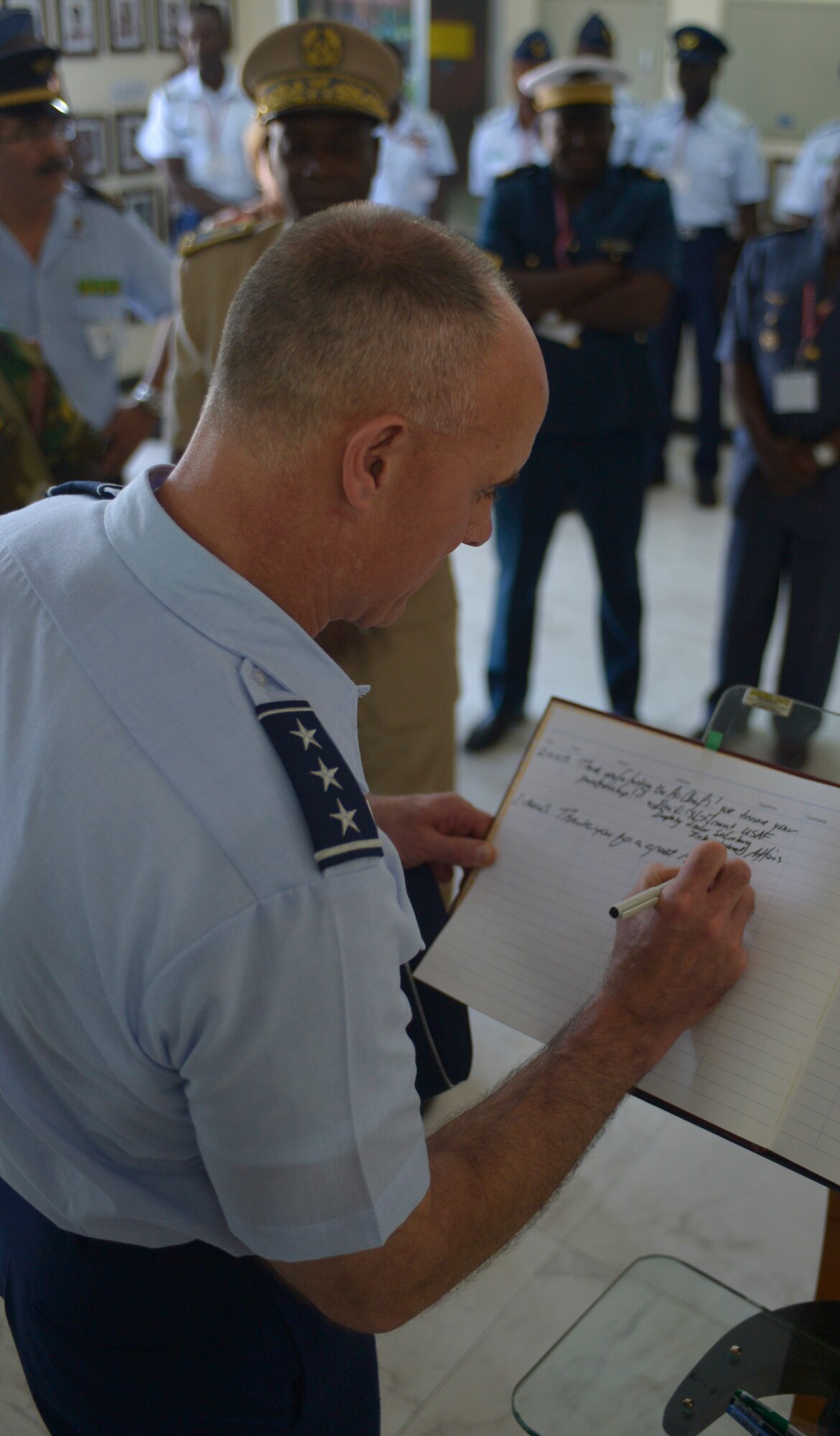 Lt. Gen. Craig A. Franklin, 3rd Air Force commander, signs a guestbook containing remarks and wishes from international heads of state, government officials and senior ranking military officers who visited Accra, Ghana, Aug. 21, 2013. Ten African air chiefs joined Franklin in recording their hopes for a safe, secure Africa at the Regional African Air Chiefs Symposium. (U.S. Air Force photo by Airman 1st Class Jordan Castelan/Released)