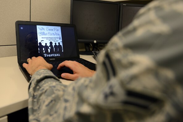 Airman 1st Class Travis Gallegos, 627th Communications Squadron cyber systems operator, reviews the final product of his Sexual Assault Response and Prevention poster Aug. 20, 2013 at Joint Base Lewis-McChord, Wash. Gallegos incorporated the Department of Defense’s sexual assault awareness theme, “We own it, we’ll solve it…together” and the teal colored ribbon, into his poster. (U.S. Air Force photo/Airman 1st Class Jacob Jimenez)