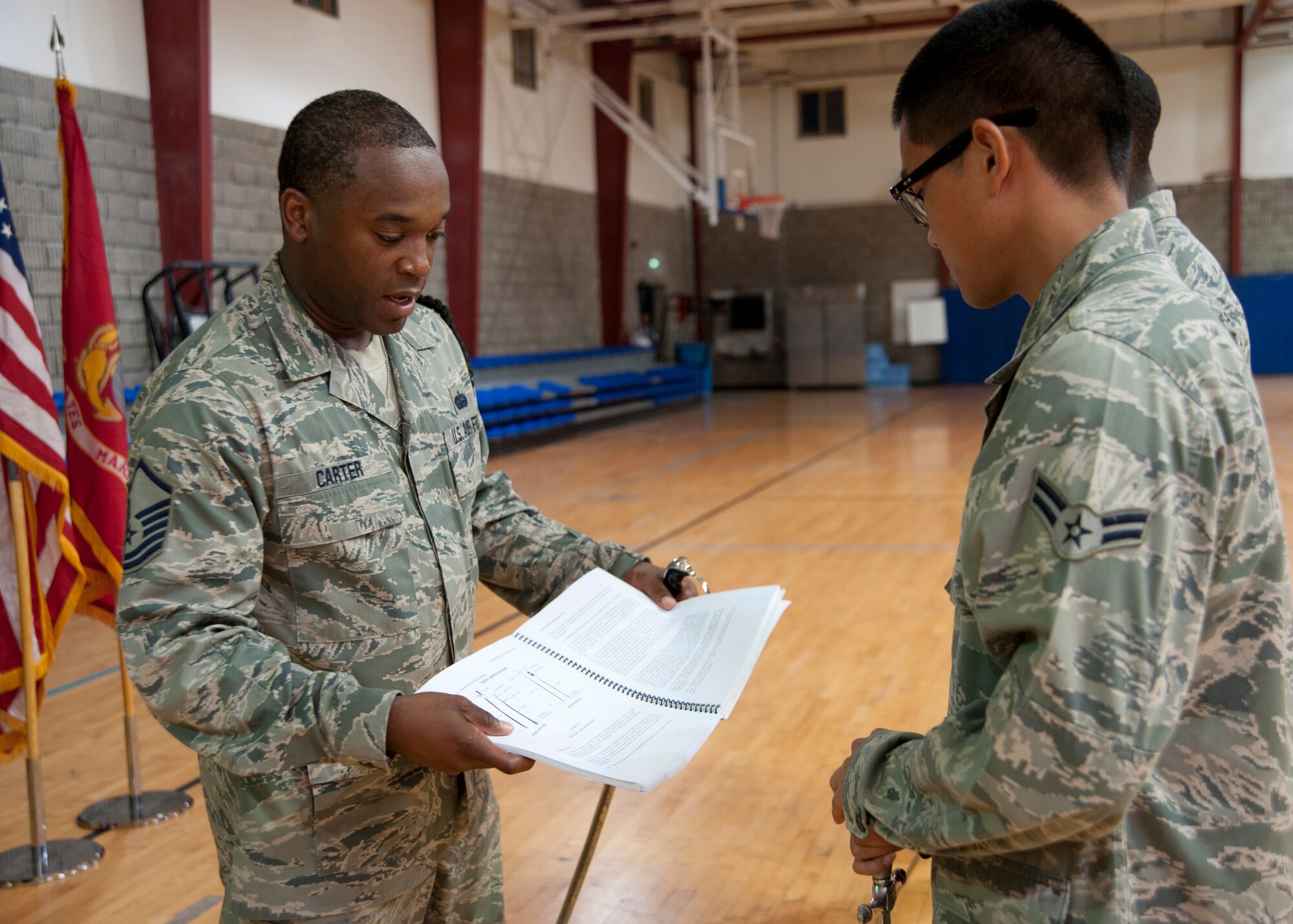 Master Sgt. Devin Carter shows honor guardsmen the instruction they follow to execute saber manuals during a weekly practice at the 379th Air Expeditionary Wing in Southwest Asia, Aug. 19, 2013. Carter is the base honor guard lead trainer deployed from Joint Base San Antonio-Lackland, Texas, and a Milwaukee, Wis., native. (U.S. Air Force photo/Senior Airman Bahja J. Jones) 