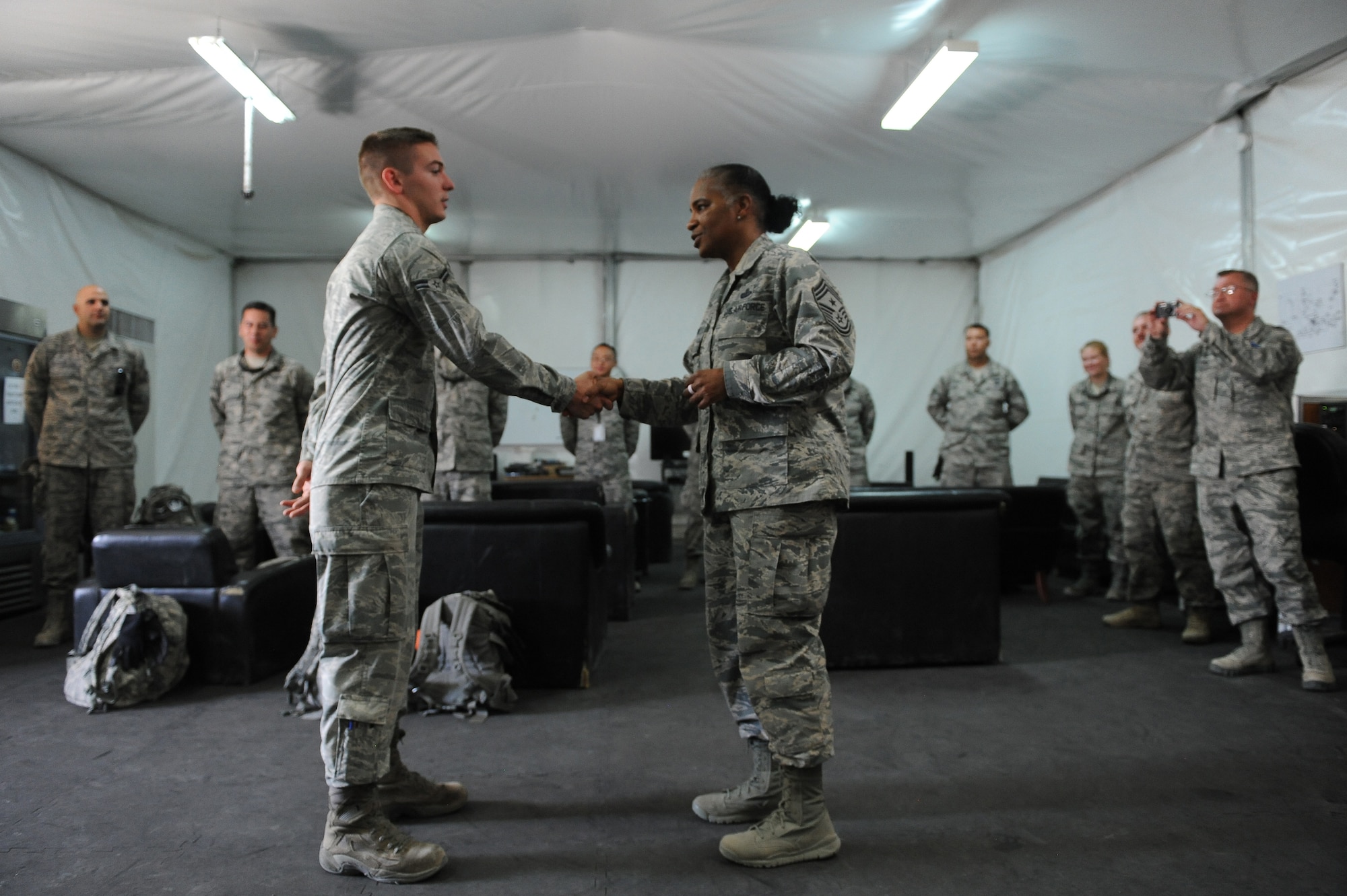 AFCENT Command Chief Master Sergeant Shelina E. Frey coins Airman 1st Class
Kristopher Benfer during a visit to the 386th Expeditionary Aircraft
Maintenance Squadron at the 386th Air Expeditionary Wing,  location in Southwest
Asia, Aug. 21, 2013. "This is for you mom and your dad for raising you
right," Frey said.  (U.S. Air Force Photo by 1st Lt. Nathan Wallin)