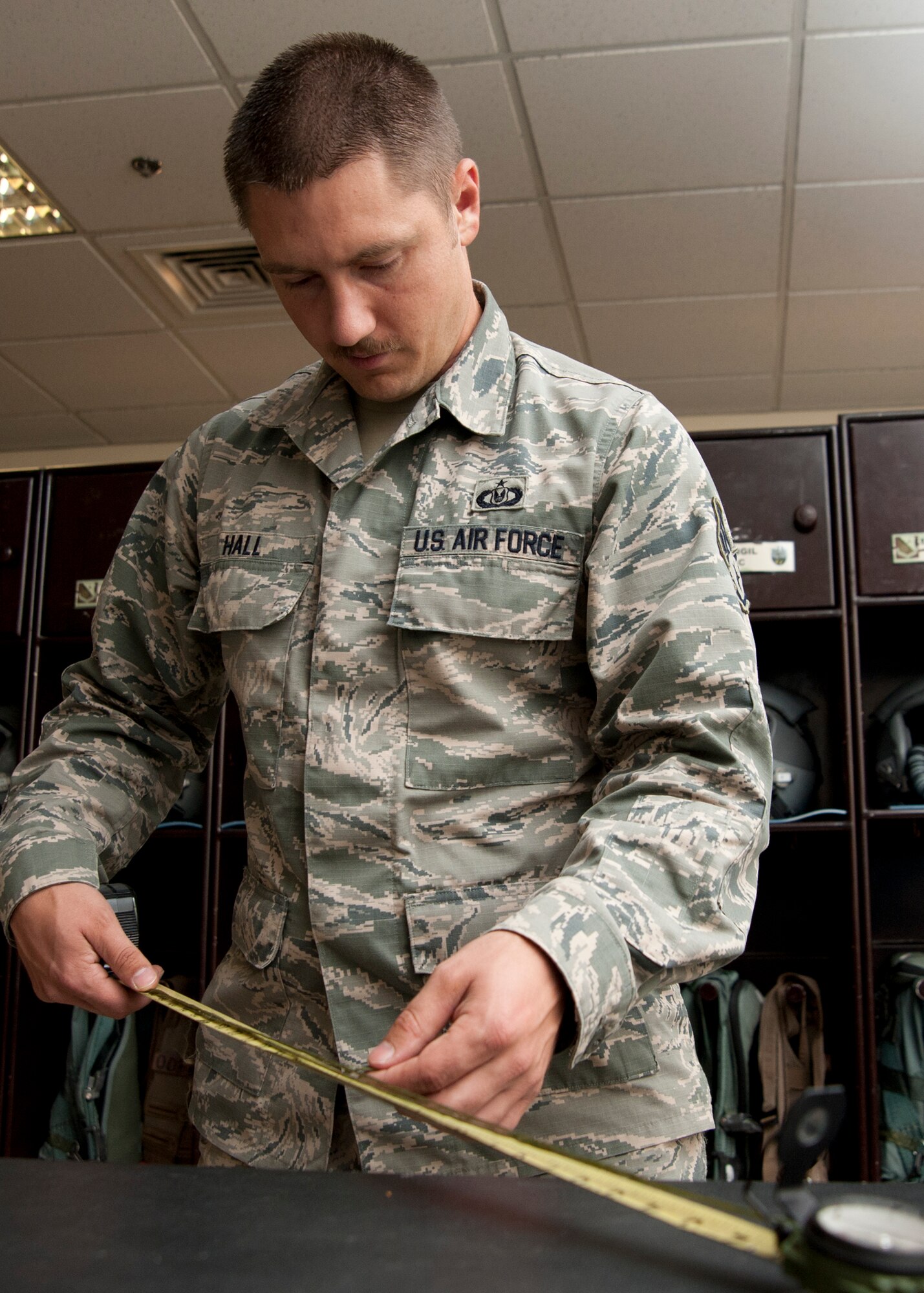 Staff Sgt. Erick Hall measures a cord attached to a lensatic compass before placement in a survival vest at the 379th Air Expeditionary Wing in Southwest Asia, Aug. 19, 2013. Hall is the 379th Expeditionary Operation Support Squadron B-1B Lancer aircrew flight equipment NCO in charge deployed from Dyess Air Force Base, Texas, and a Fort Worth, Texas, native. (U.S. Air Force photo/Senior Airman Bahja J. Jones) 