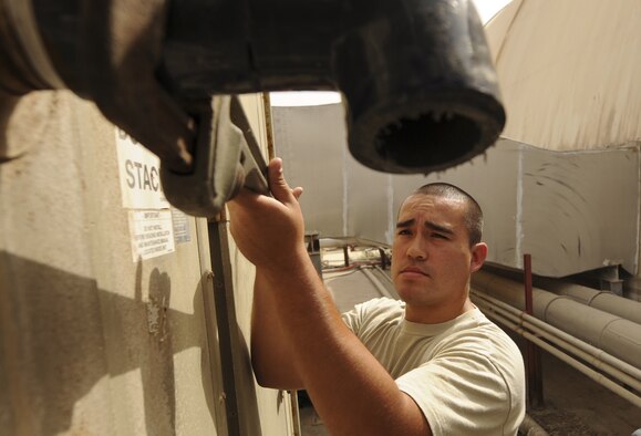 U.S. Air Force Senior Airman Dennis Weaver, 380th Expeditionary Civil Engineer Squadron heating, ventillation, and air conditioning journeyman, uses a pipe wrench to take off a pipe for re-fitting at an undisclosed location in Southwest Asia Aug. 7, 2013. The pipe he is trying to re-fit belongs to an air conditioning system for a U-2 Dragon Lady hangar here. Weaver calls Sacramento, Calif., home and is deployed from Luke Air Force Base, Ariz. (U.S. Air Force photo by Staff Sgt. Jacob Morgan)