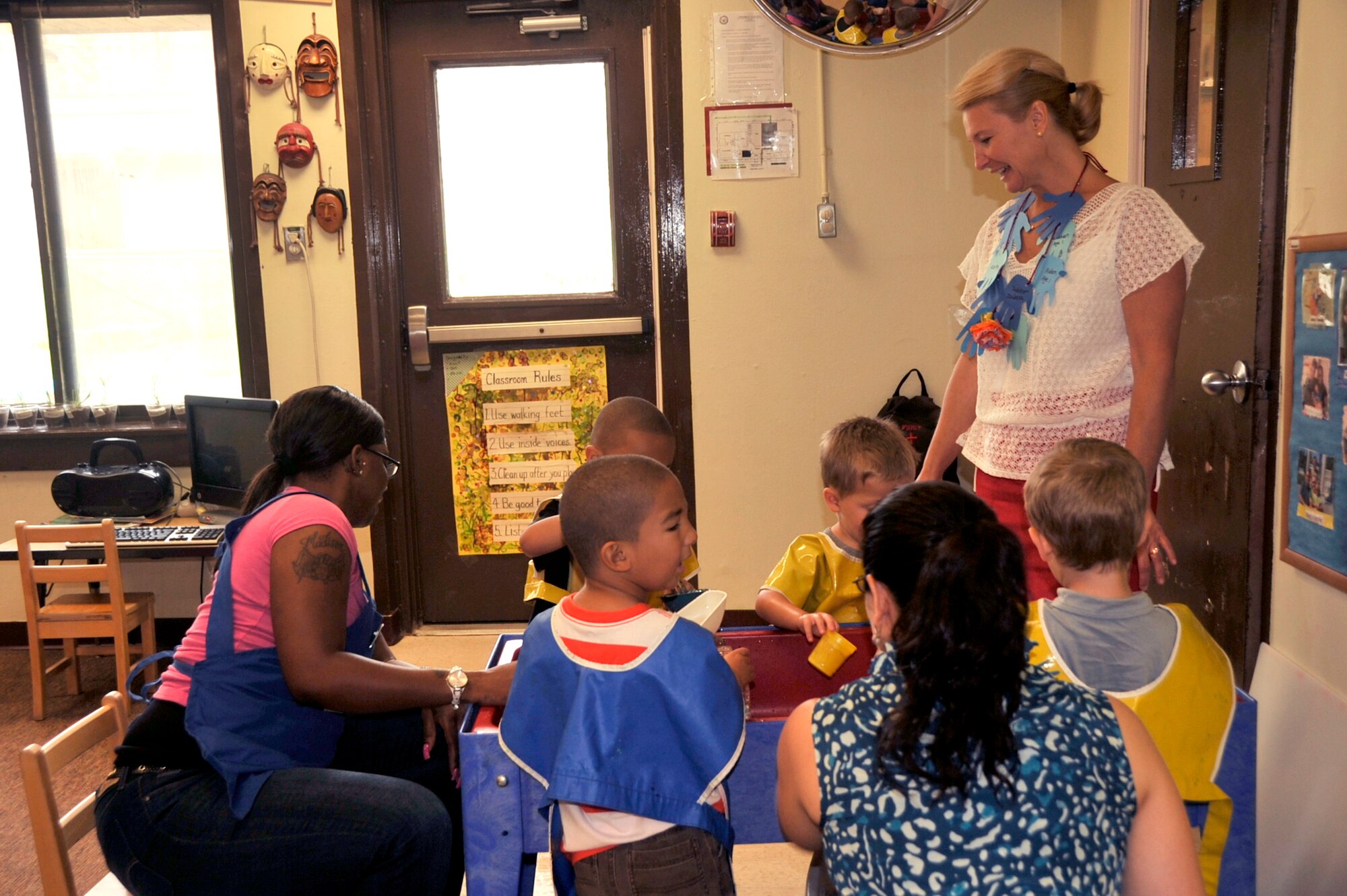 Athena Cody, wife of Chief Master Sgt. of the Air Force James A. Cody, takes a moment to greet children at the Child Development Center during a tour of Osan Air Base, Republic of Korea, Aug. 23, 2013. Mrs. Cody and Betty Welsh, wife of Air Force Chief of Staff Gen. Mark A. Welsh III, visited the CDC to discuss and understand unique characteristics of life at Osan and the limitations for child care.