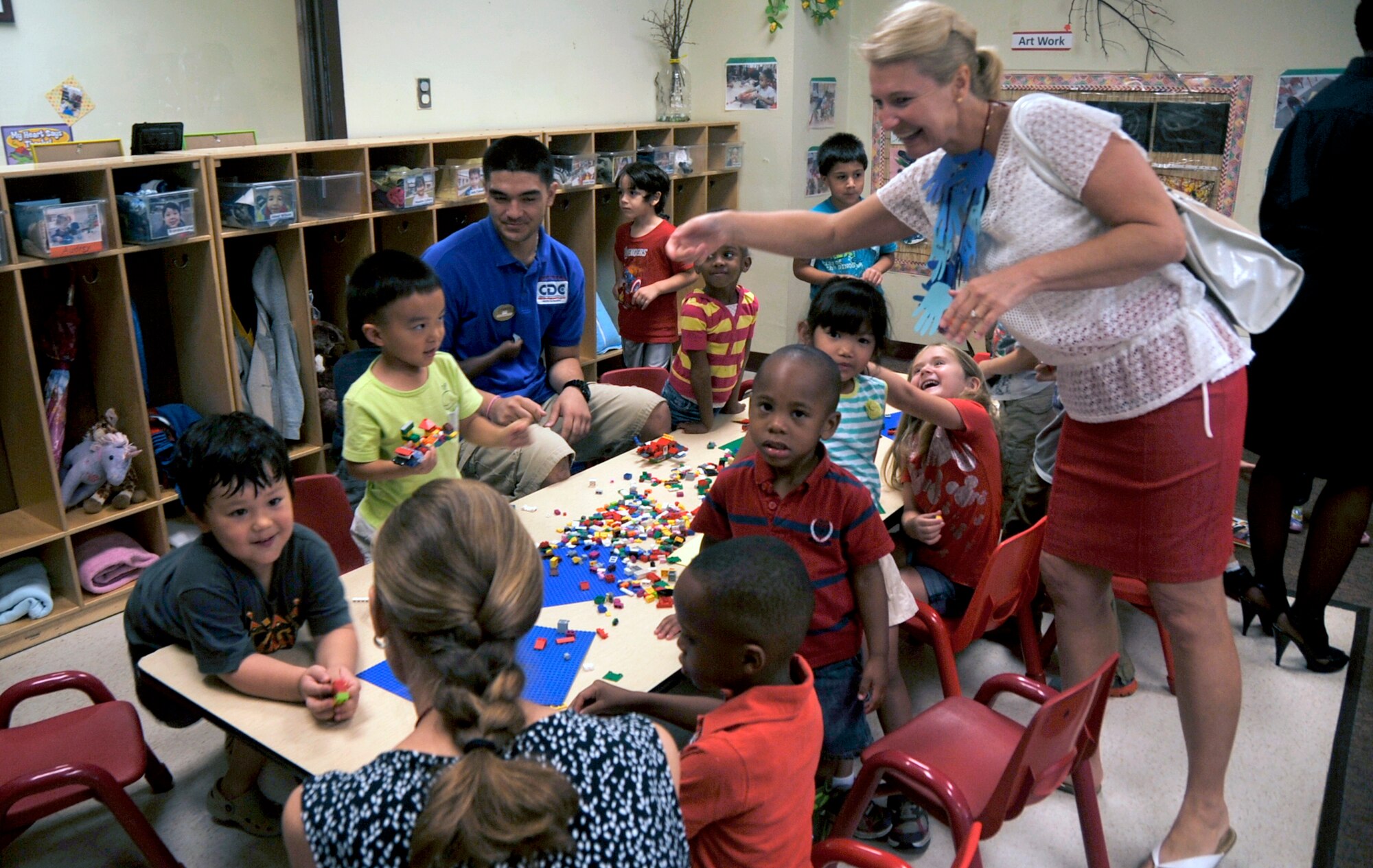 Athena Cody, wife of Chief Master Sgt. of the Air Force James A. Cody, takes a moment to greet children at the Child Development Center during a tour of the facility at Osan Air Base, Republic of Korea, Aug. 23, 2013. Cody, along with Betty Welsh, wife of Air Force Chief of Staff Gen. Mark A. Welsh III, visited the CDC to discuss and understand unique characteristics of life at Osan and the limitations for child care.