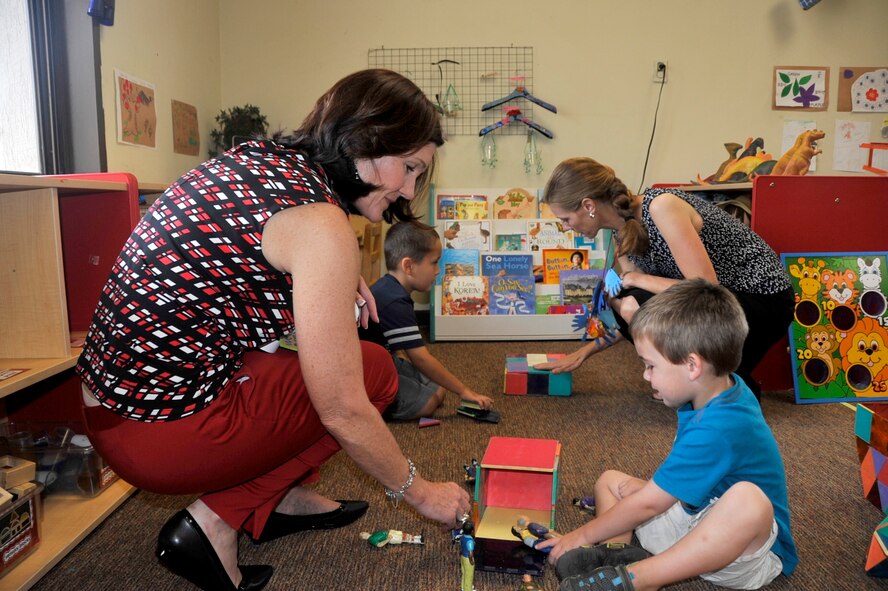 Betty Welsh, wife of Air Force Chief of Staff Gen. Mark A. Welsh III, takes a moment to greet children at the Child Development Center during a tour at Osan Air Base, Republic of Korea, Aug. 23, 2013. Mrs. Welsh was accompanied by Athena Cody, wife of Chief Master Sgt. of the Air Force James A. Cody, who toured the CDC to discuss and understand unique characteristics of life at Osan and the limitations for child care.