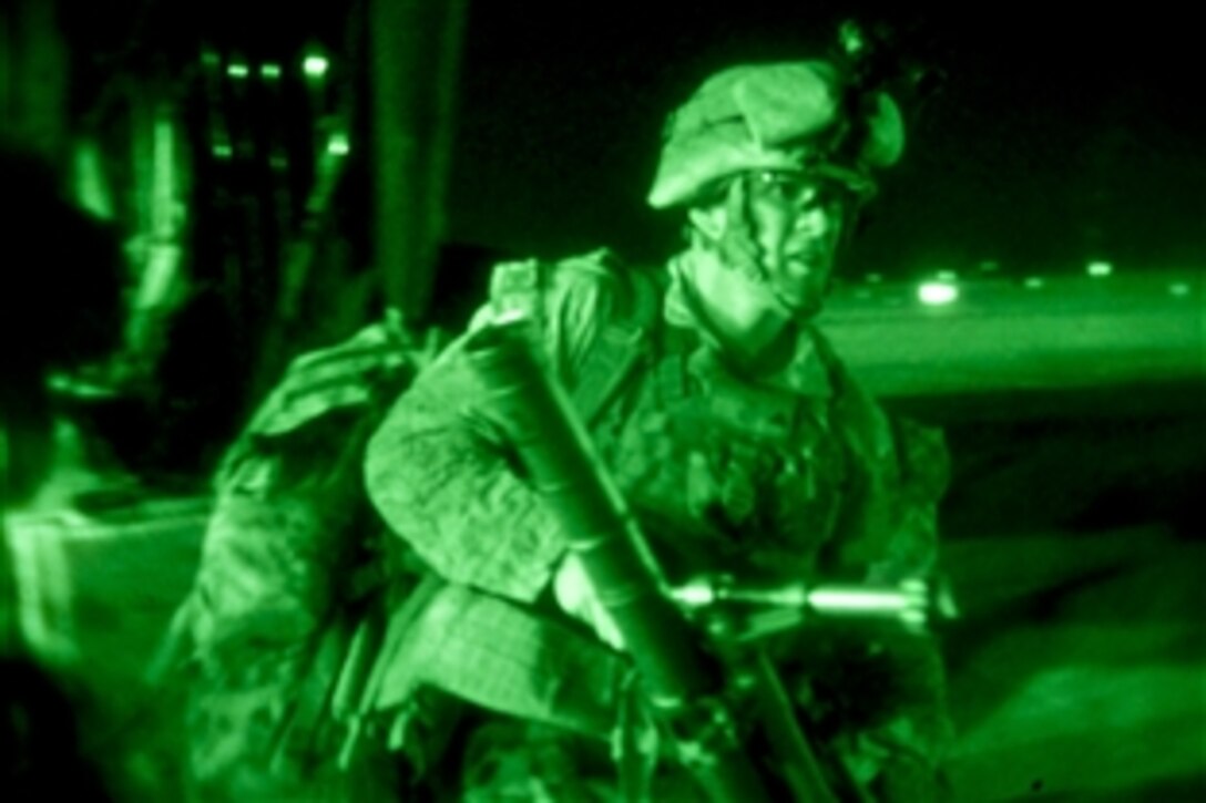 As seen through a night-vision device, U.S. Marines and Afghan forces exit a CH-53E Super Stallion helicopter after completing an air interdiction exercise on Camp Bastion in Helmand province, Afghanistan, Aug. 20, 2013.