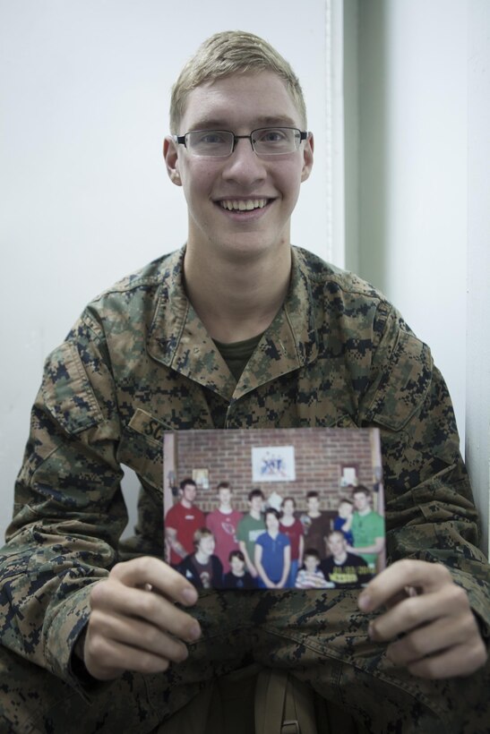 Lance Cpl. Gregg J. Schaefer, a landing support specialist with Combat Logistics Battalion 31, 31st Marine Expeditionary Unit, holds a picture of himself with his 11 brothers and sisters here, Aug. 21. With his siblings serving as the motivation to change his ways, Schaeffer transformed himself from troublemaker to role model by becoming a Marine. The 31st MEU is the Marine Corps’ force in readiness in the Asia-Pacific region and the only continuously forward deployed MEU. 
 
