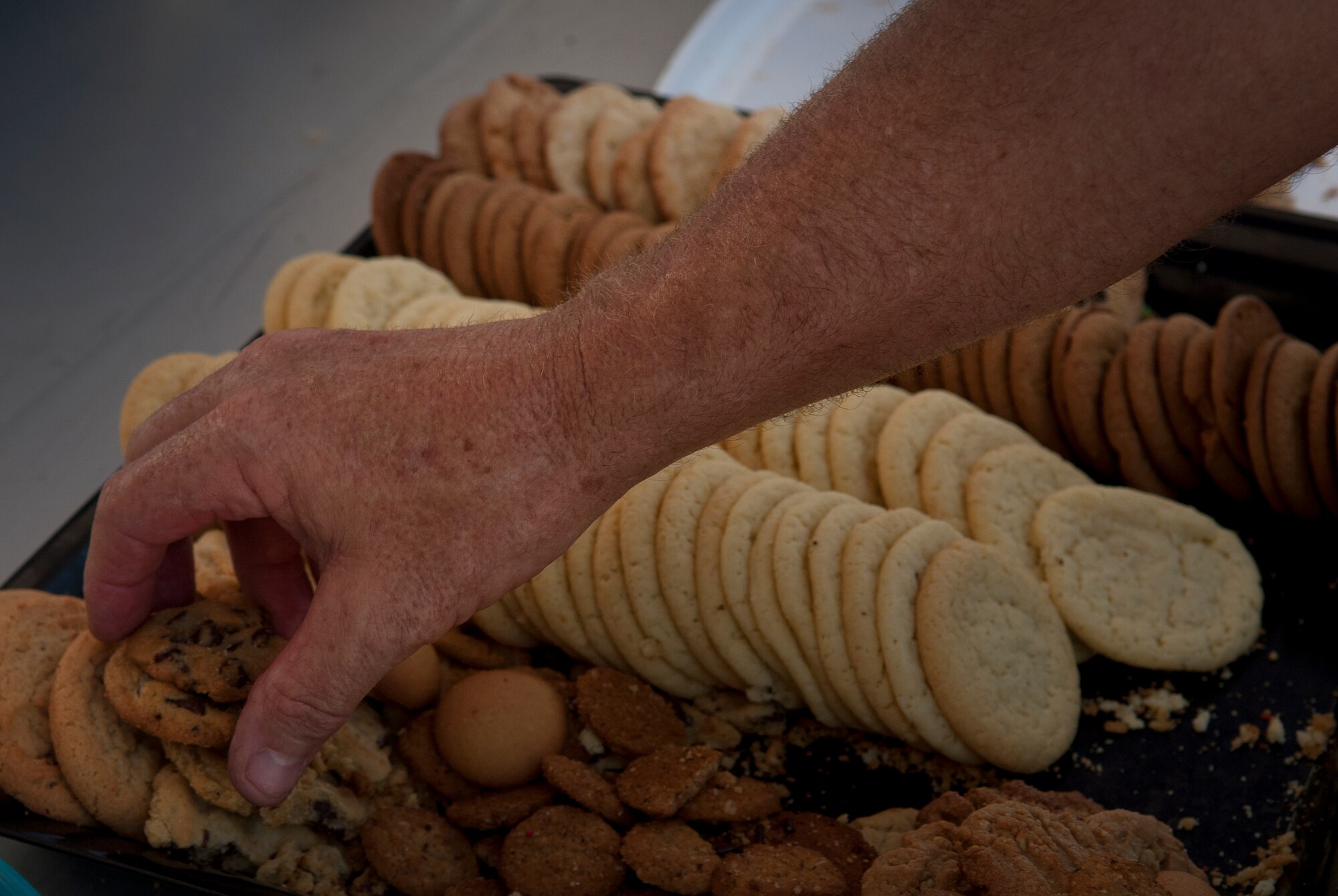 A Hotter'N Hell Hundred rider reaches for some cookies at the Sheppard Air Force Base, Texas, rest stop Aug. 24, 2013. As part of the event, Sheppard volunteers also helped riders needing a break at the last rest stop before the finish line. Across all the rest stops, riders consumed more than 20,000 bananas, more than 9,000 oranges, more than 8,000 pickles, 2,800 gallons of PowerAde and 10,000 gallons of water. In all, more than 70,000 pounds of ice was also used. (U.S. Air Force photo/Staff Sgt. Mike Meares)