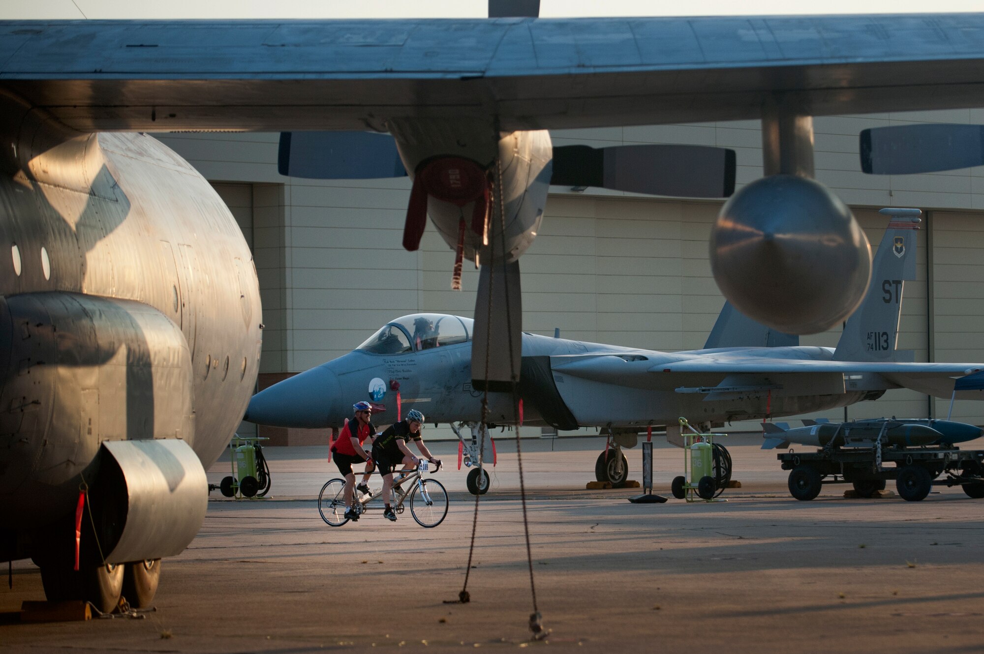 HotterN' Hell Hundred riders roll through Sheppard Air Force Base, Texas, and "Airpower Alley" Aug. 24, 2013. As part of the event, hundreds of Sheppard volunteers helped riders needing a break at the last rest stop before the finish line. Across all the rest stops, riders consumed more than 20,000 bananas, more than 9,000 oranges, more than 8,000 pickles, 2,800 gallons of PowerAde and 10,000 gallons of water. In all, more than 70,000 pounds of ice was also used. (U.S. Air Force photo/Staff Sgt. Mike Meares)