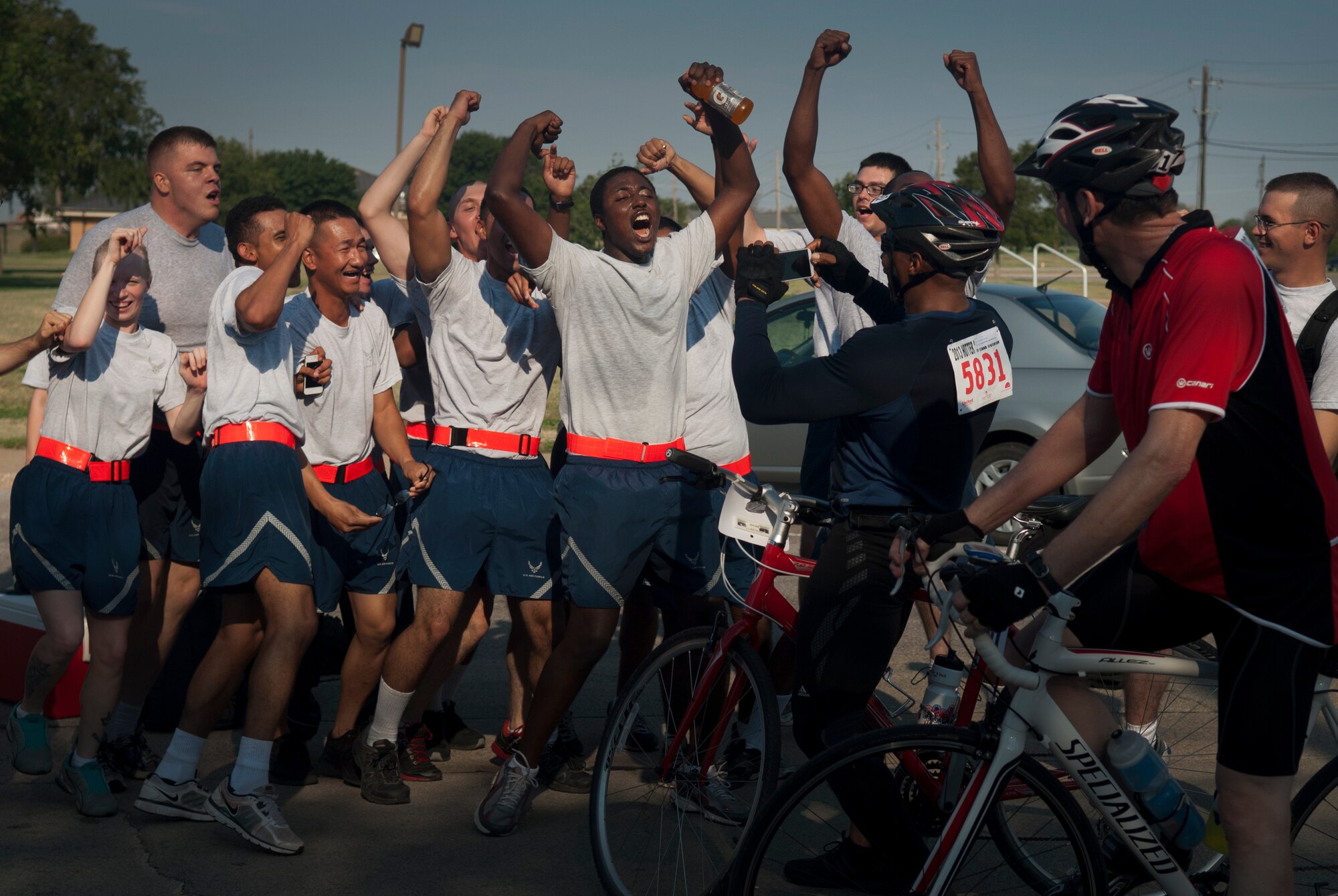 HotterN' Hell Hundred riders stop and take their photo with 82nd Training Wing Airmen in training at Sheppard Air Force Base, Texas, Aug. 24, 2013. As part of the event, hundreds of Sheppard volunteers helped riders needing a break at the last rest stop before the finish line. Across all the rest stops, riders consumed more than 20,000 bananas, more than 9,000 oranges, more than 8,000 pickles, 2,800 gallons of PowerAde and 10,000 gallons of water. In all, more than 70,000 pounds of ice was also used. (U.S. Air Force photo/Staff Sgt. Mike Meares)