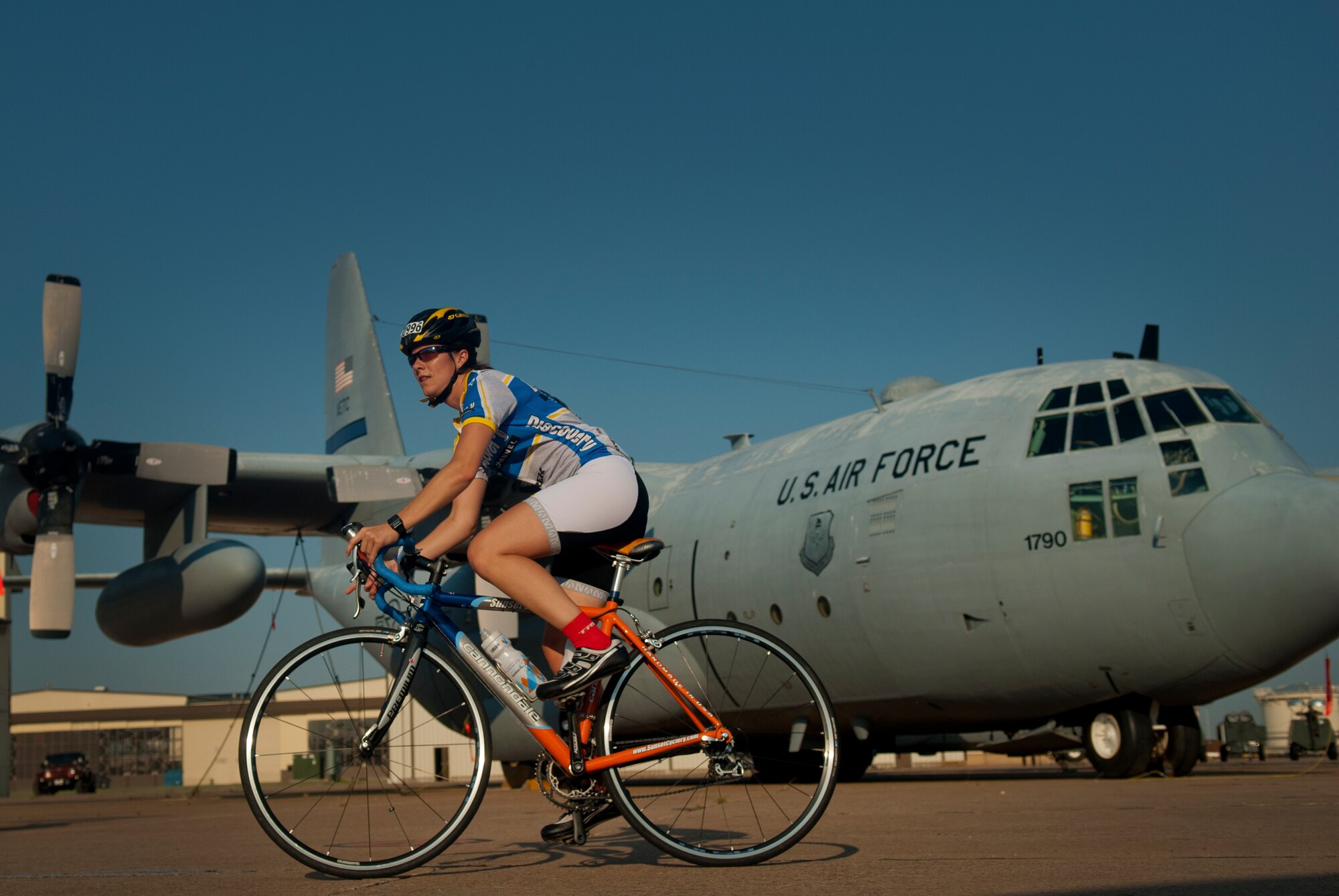 A HotterN' Hell Hundred rider rolls through Sheppard Air Force Base, Texas, and "Airpower Alley" Aug. 24, 2013. An pair of C-130 Hercules, F-16 Falcon, an A-10 Thunderbolt II, a T-38 Talon, T-6 Texan II and an F-15 Eagle from the training ramp were on display for riders to stop an take a look at with pilots on hand to answer questions. As part of the event, hundreds of Sheppard volunteers helped riders needing a break at the last rest stop before the finish line. Across all the rest stops, riders consumed more than 20,000 bananas, more than 9,000 oranges, more than 8,000 pickles, 2,800 gallons of PowerAde and 10,000 gallons of water. In all, more than 70,000 pounds of ice was also used. (U.S. Air Force photo/Staff Sgt. Mike Meares)
