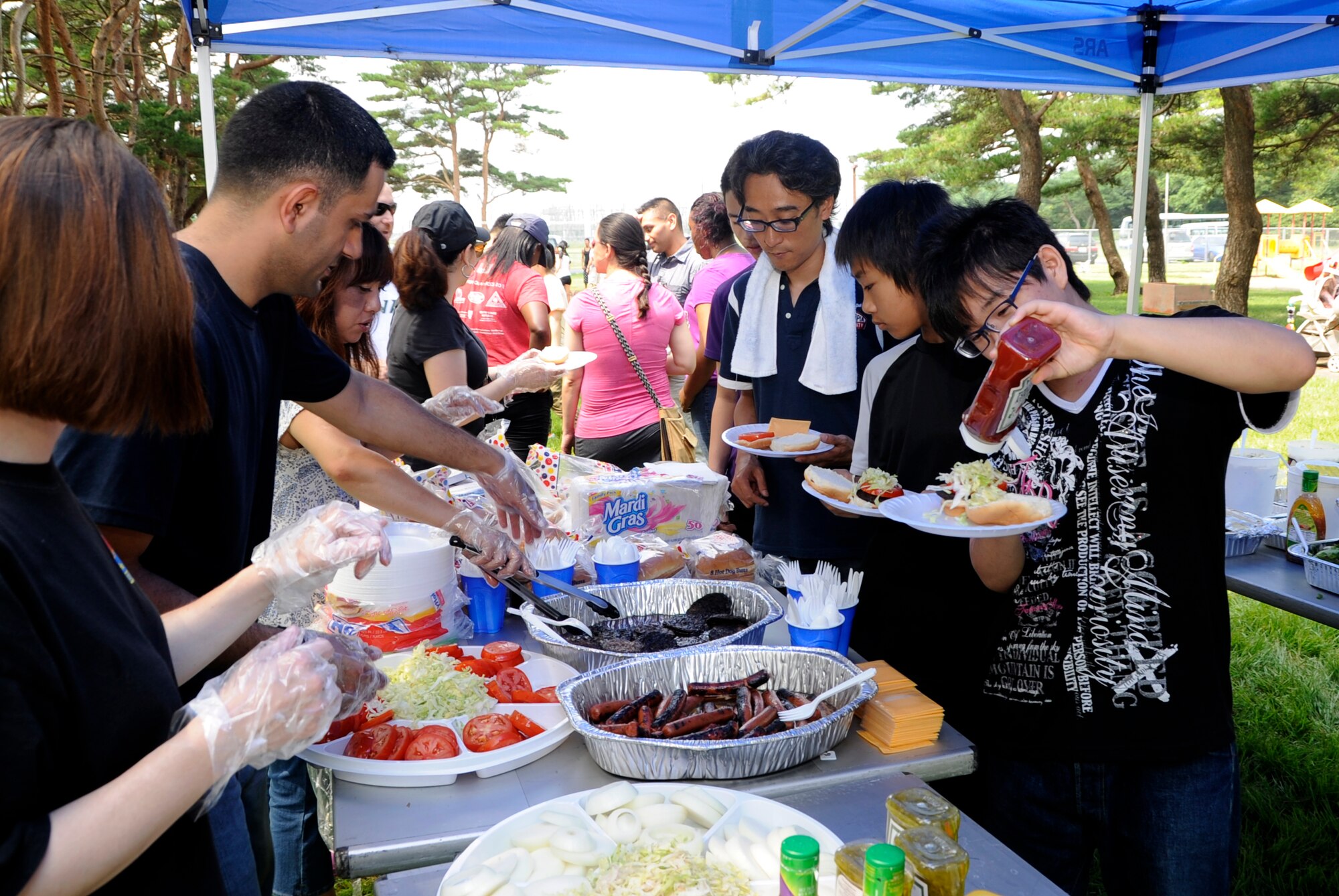 Attendees of the 35th Logistics Readiness Squadron picnic get food at Misawa Air Base, Japan, Aug. 24, 2013. Money for the picnic is raised throughout the year with donations and fundraising events on American Day, Freedom Fest and more. (U.S. Air Force photo by Airman 1st Class Kaleb Snay)