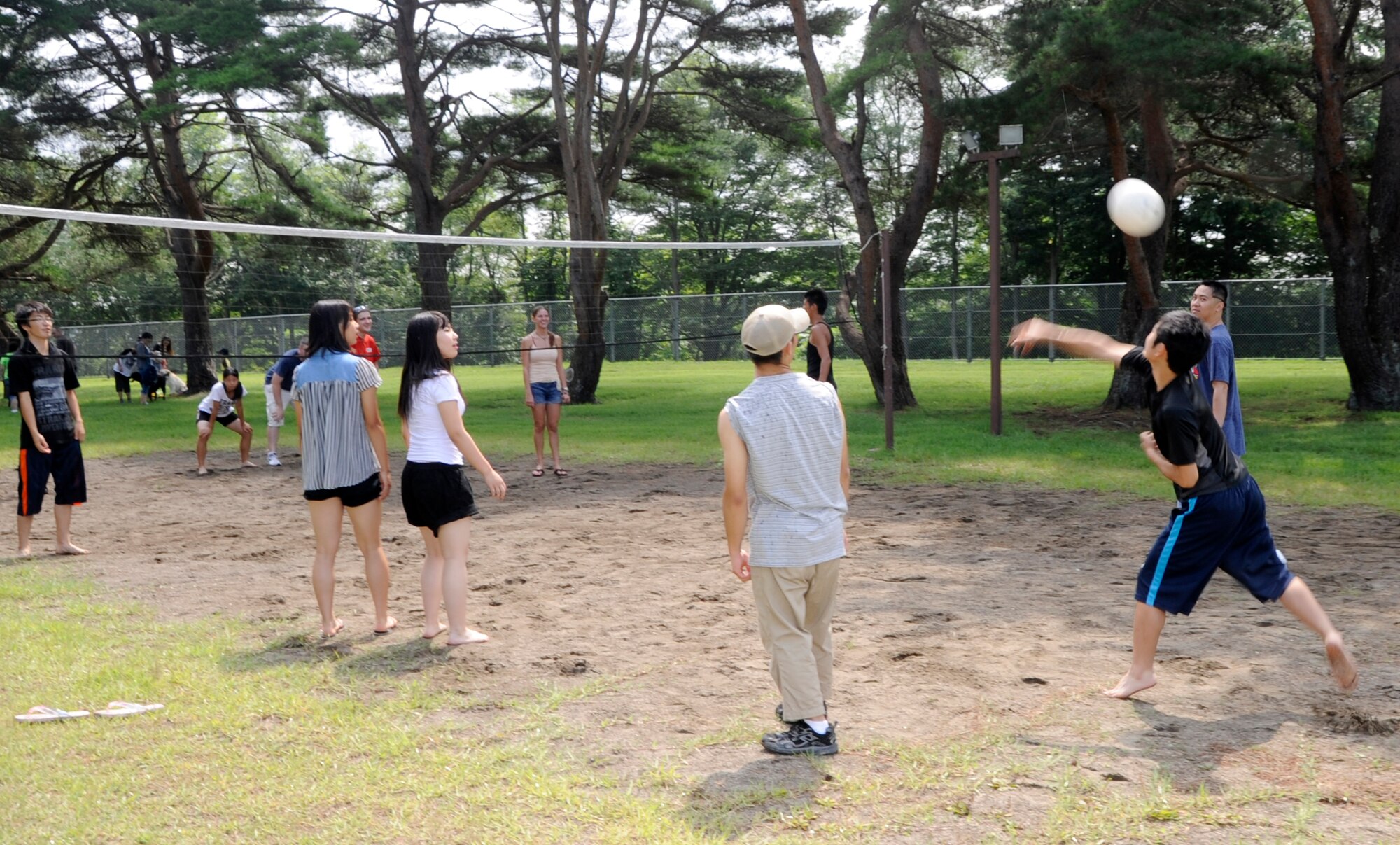 Attendees of the 35th Logistics Readiness Squadron picnic join together to play volleyball at Misawa Air Base, Japan, Aug. 24, 2013. Since the late 1960’s, the 35 LRS have built a tradition of visiting the Fiju Seiboen orphanage once a year buying gifts and spreading cheer to the children during Christmas. In 2011 a new tradition was born where the children would come out for some summer fun during the 35 LRS picnic. (U.S. Air Force photo by Airman 1st Class Kaleb Snay)