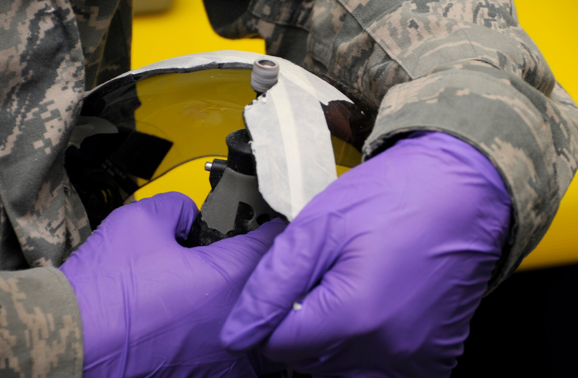 U.S. Air Force Airman 1st Class Francisco McGlothin, 35th Operations Support Squadron aircrew flight equipment technician, grinds down a Joint Helmet Mounted Cueing System visor at Misawa Air Base, Japan, Aug. 22, 2013. Each JHMCS must be custom fitted to pilots to ensure it fits and works properly, and can take up to six hours to complete as they must trim one-eighth of an inch at a time. (U.S. Air Force photo by Airman 1st Class Kaleb Snay)