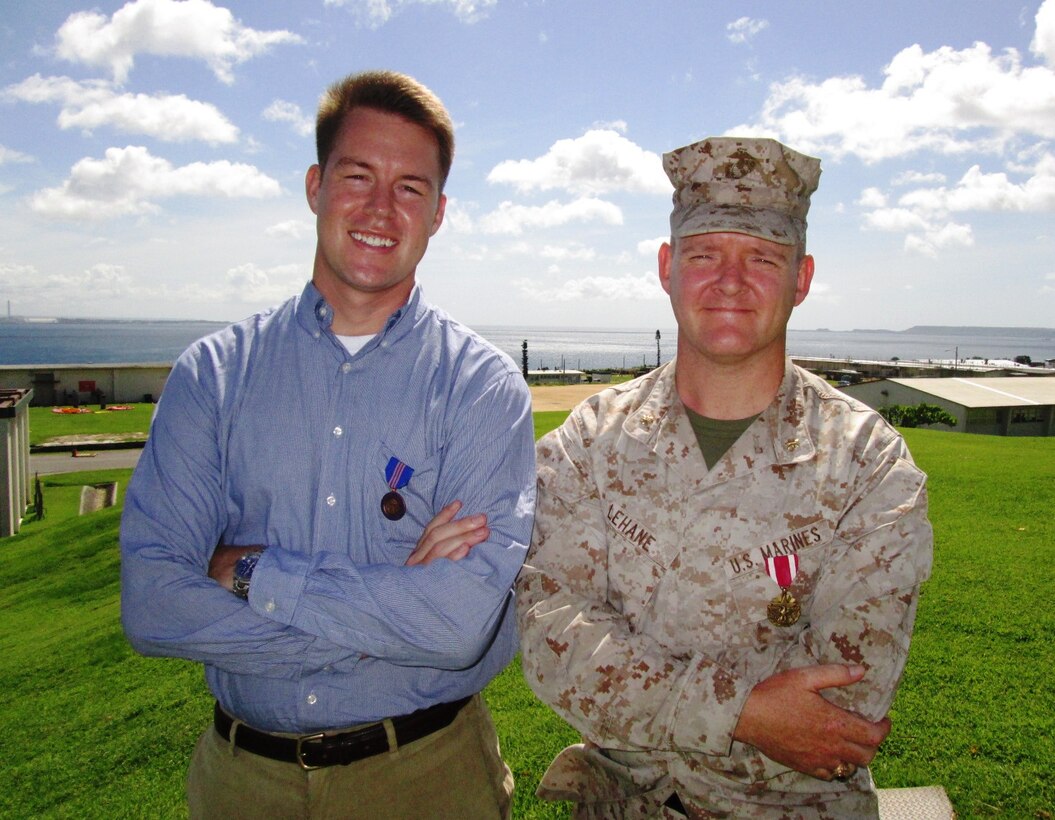 Two dedicated individuals, one a civilian Marine and the other a Marine officer, both working on the III Marine Expeditionary Force staff, recently were awarded for their efforts and contributions to mission success during a ceremony here, May 20. Maj. John G. Lehane, Northeast Asia lead planner, G-5 plans, III MEF, (right) was awarded the Meritorious Service Medal for his extensive multilateral work and superior operational planning in support of wide-ranging III MEF operations and exercises over his three-year tour.  Ian D. Macleod, Center for Naval Analysis Representative to III MEF, was awarded the Commendation for Meritorious Civilian Service for his work within III MEF, providing well-developed, insightful analyses and decision support tools to the III MEF commanding general and his staff for the past three years. The significance of their awards reaches far beyond their individual efforts, and represents an intertwined and mutually supportive history of service to the Marine Corps, particularly with III MEF in Okinawa, Japan.