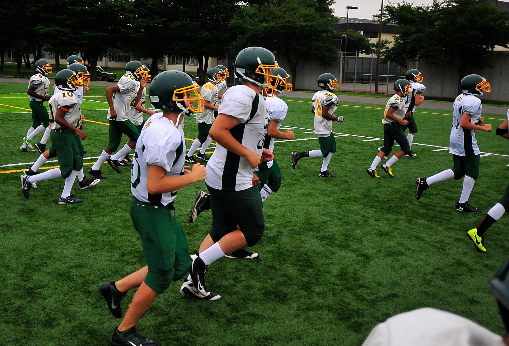 Students from the Edgren High School football team take the field for the first day of the bilateral football camp with the Tohoku Gakuin University, a Division 1 college located in Sendai, at Misawa Air Base, Japan, Aug. 16, 2013. Edgren High School hosted the TGU football team for a three day football camp this summer. (U.S. Air Force photo by Staff Sgt. Nathan Lipscomb)