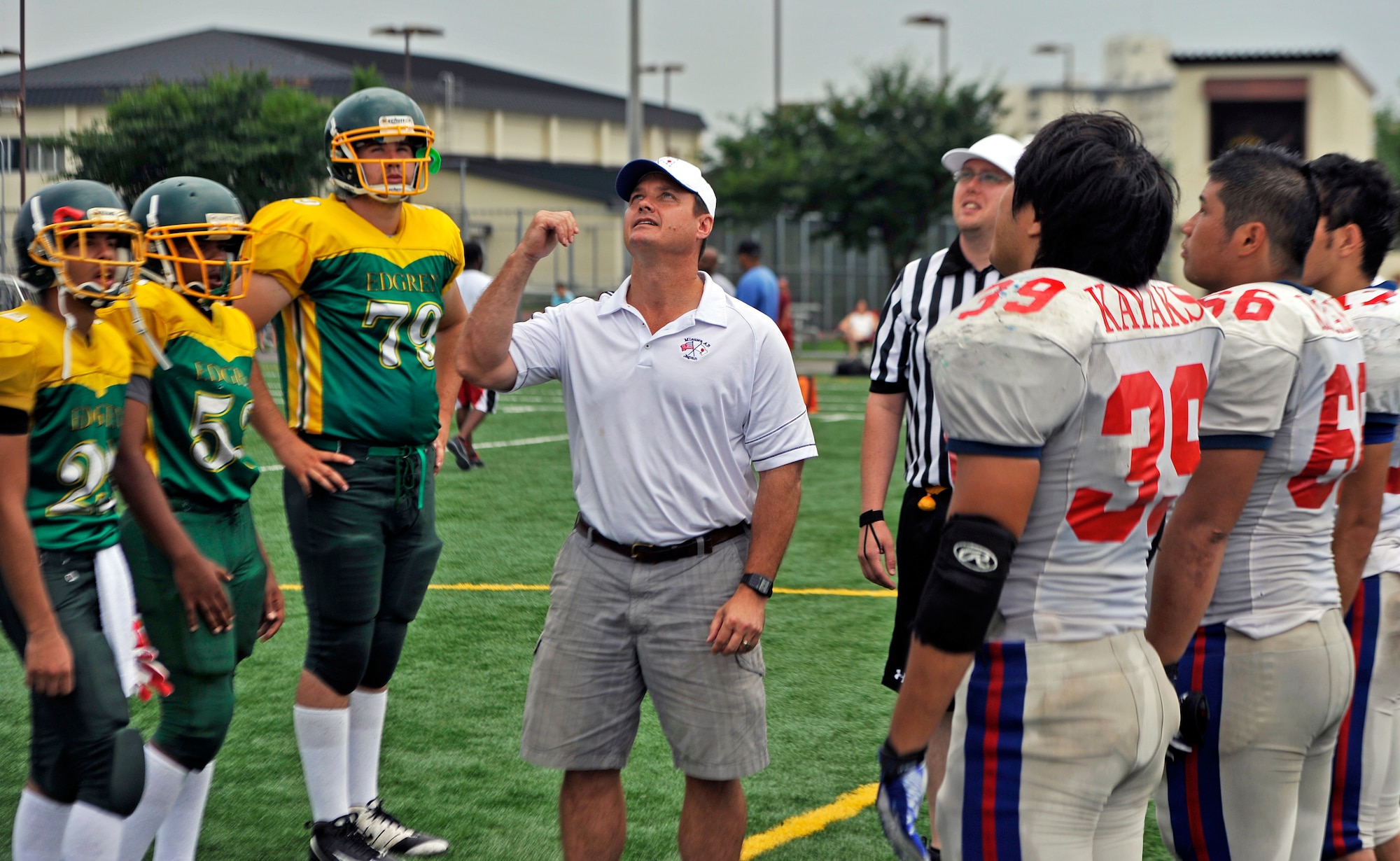 U.S. Air Force Col. Matthew Dana, 35th Fighter Wing vice commander, flips the coin before the start of Edgren High School’s scrimmage against the Tohoku Gakuin University at Misawa Air Base, Japan, Aug. 18, 2013. Players from the university spent the weekend with players from Edgren while attending a three-day football camp. (U.S. Air Force photo by Airman 1st Class Zachary Kee)