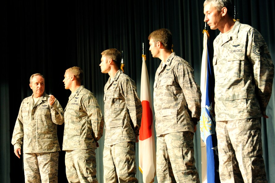 U.S. Air Force Capt. Michael Kingry, 18th Operation Support Squadron chief of weapon tactics, explains a 320-mile rescue mission to Air Force Chief of Staff Gen. Mark A. Welsh III and the audience during an Airman's call on Kadena Air Base, Japan, Aug. 21, 2013. Five members of the 33rd Rescue Squadron were awarded the Distinguished Flying Cross with valor for their service during a mission in which they were under direct enemy fire and rescued critically wounded coalition soldiers during a deployment in 2012. (U.S. Air Force photo by Airman 1st Class Hailey R. Davis)