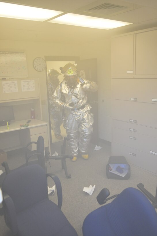 Airmen from the 115th Fighter Wing participated in a unexpected exercise designed to test mission readiness on base Aug. 23, 2013.  An unauthorized front-gate entry and a simulated explosion started the exercise leading to a 'fire' in Building 411.   The explosive ordinance disposal team here added realism by filling that building up with smoke, giving the rescue teams a challenge when removing the victims.  (Air National Guard photo by Staff Sgt. Ryan Roth)