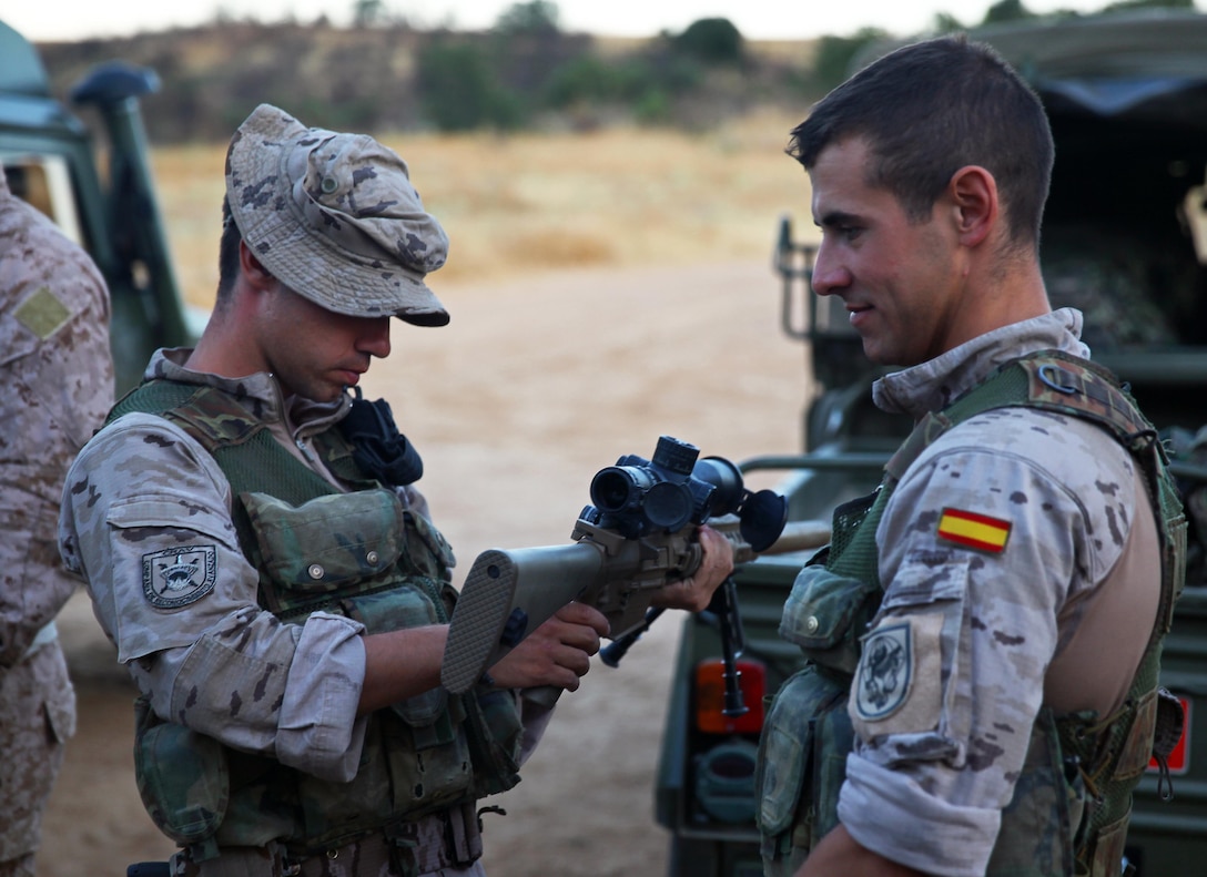 Spanish snipers Cpl. Bruno Dopico, left, and Pvt. Jose Enriquez Bolona inspect an American M110 sniper rifle prior to conducting advanced marksmanship training alongside U.S. Marines with Special Purpose Marine Air-Ground Task Force Crisis Response July 29, 2013 at the Principe Training Camp in Spain. The bilateral event took place from July 29 to Aug. 1 and served to sustain marksmanship proficiency and build enduring relationships between each military. The Marines and sailors of SP-MAGTF Crisis Response provide a limited-defense crisis response capability in support of U.S. and partner-nation security interests within their area of responsibility and also participate in training events with regional partners. The unit is temporarily postured in Spain. (Official U.S. Marine Corps photo by Cpl. Michael Petersheim)