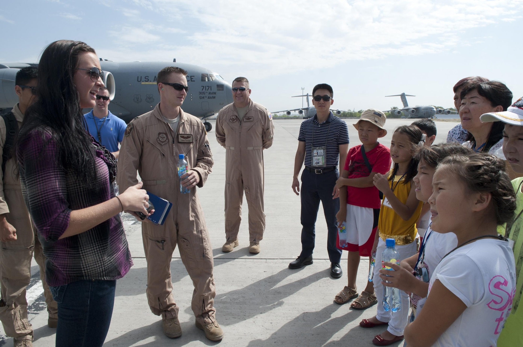 2nd Lt. Liya Smolina translates an explanation for the role of the aircraft on the flightline to visiting Kyrgyz students at Transit Center at Manas, Kyrgyzstan, August 22, 2013. English is Smolina's second language, but she's spent most of her life speaking it and only had the opportunity to improve on her original Russian language on this deployment.