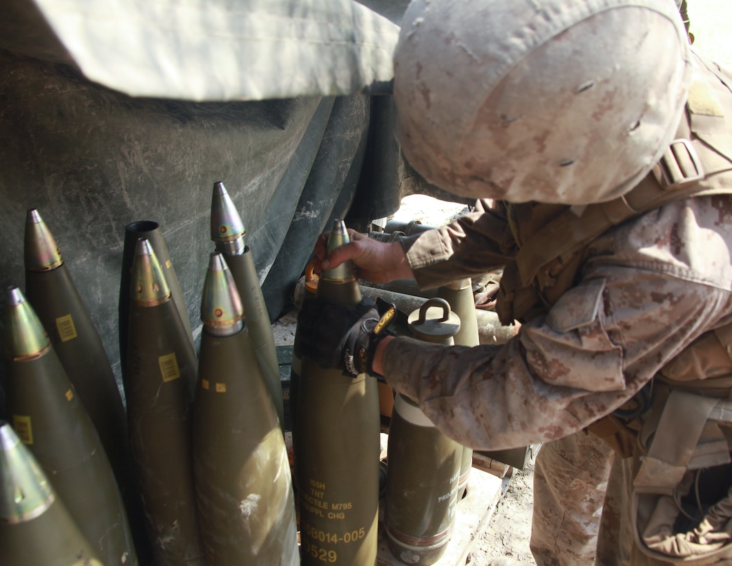 A Marine from Golf Battery, 2nd Battalion, 10th Marine Regiment, screws on fuses to high explosive 155mm rounds during a training exercise aboard Marine Corps Base Camp Lejeune, N.C., June 26, 2013. A single 155 mm round weighs 90 pounds and can be launched out of a canon more than 30,000 meters.