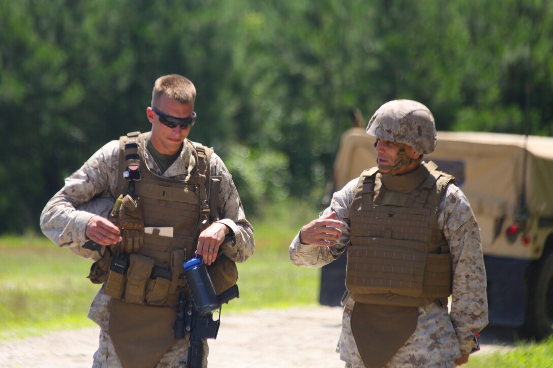 First Lt. Eric Amundson, the executive officer with Golf Battery, 2nd Battalion, 10th Marine regiment speaks with Col. Clifford Weinstein, the regiment's commanding officer, at Gun Position 23 aboard Marine Corps Base Camp Lejeune, N.C., during a training exercise June 26, 2013. The visit from Weinstein raised the Marines morale after days of inclement weather.