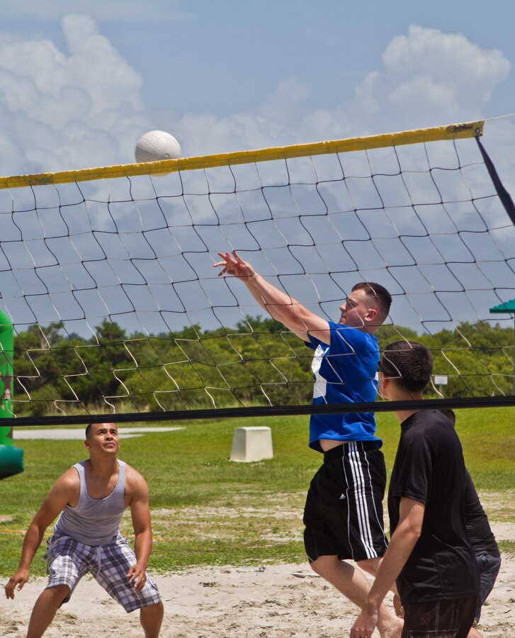 A Marine with 2nd Marine Regiment hits a volley ball back over the net during the intramural games going on at the regiment's fourth annual Beach Bash, July 2, 2013 at Onslow Beach. During the event families, Marines and sailors had the opportunity to dunk senior leadership in the dunk tank, compete in a pie-eating contest, jump in inflatable bounce houses and participate in various intramural sports.