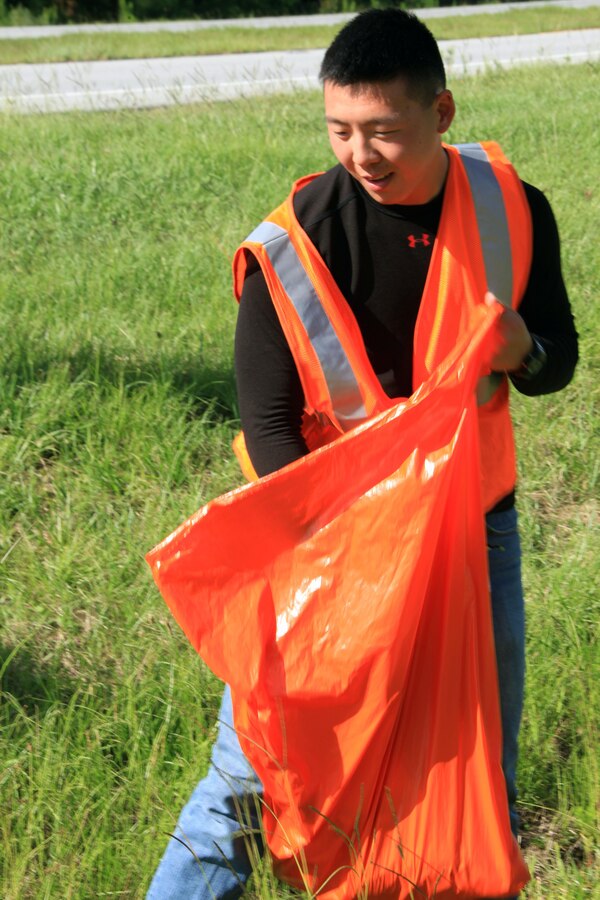 Corporal Andrew Y. Zheng, a saxophone player with the 2nd Marine Division Band and St. Louis native, dedicates his free time by picking up trash along New Bern Hwy., July 20, 2013. Zheng also gets a group together to perform music for different functions as another way to give back to the community.