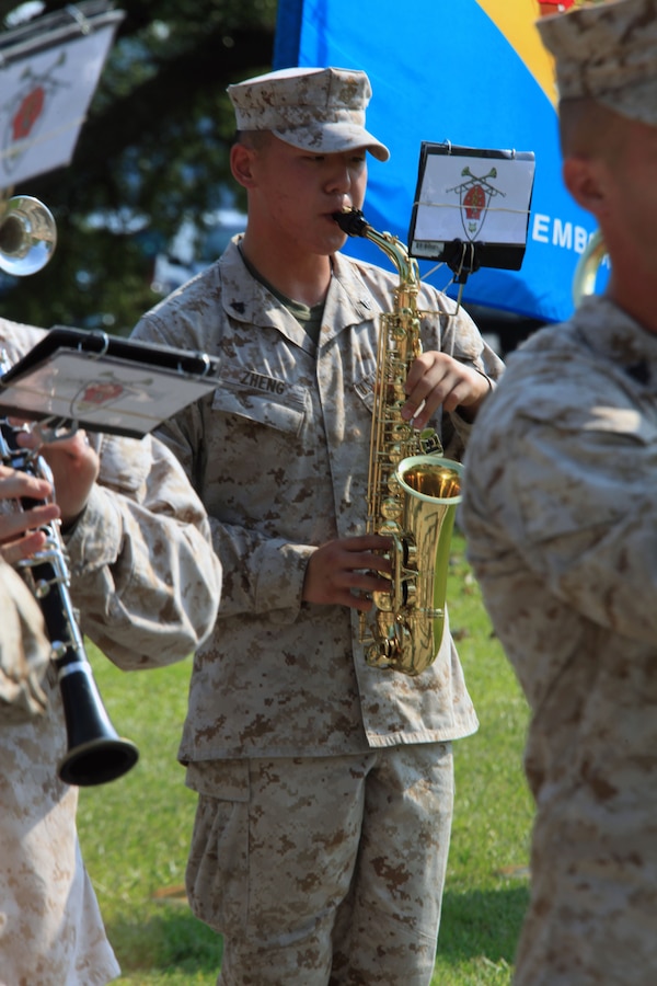 Corporal Andrew Y. Zheng, a saxophone player with the 2nd Marine Division Band and St. Louis native, performs at a retirement ceremony aboard Marine Corps Base Camp Lejeune, July 18, 2013. After dedicating his time to the Marine Corps, Zheng also gives back to the local community through volunteer service.