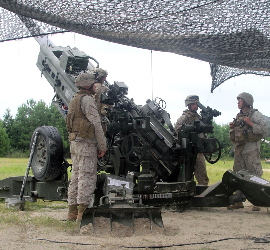 Marines with 10th Marine Regiment prepare to fire a howitzer as part of their fire support coordination exercise aboard Marine Corps Base Camp Lejeune, July 22-24, 2013. The FSCEX brought together 10th Marine Regiment and members of the Air Naval Gunfire Liaison Company to practice fire missions.