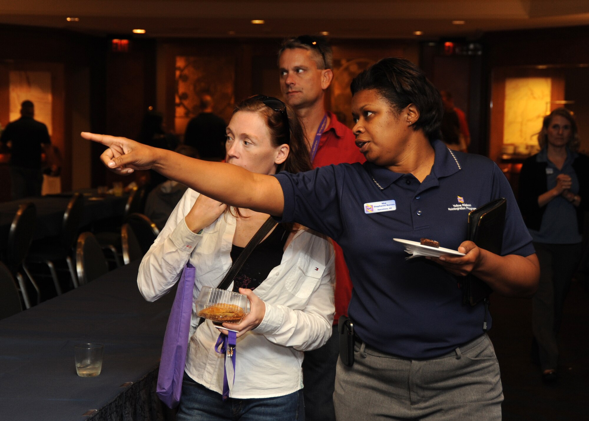 Maj. Stephanie Barnes, operations officer for the U.S. Air Force Reserve Yellow Ribbon Program "Purple" team, gives a tour of the premises to arriving participants at a Yellow Ribbon Program event in Arlington, Va., on Aug. 23, 2013.  The Air Force Yellow Ribbon Program provides Reserve members and their families with information, services, referrals, and proactive outreach opportunities throughout the deployment cycle.  (U.S. Air Force photo by Tech. Sgt. Peter R. Miller).