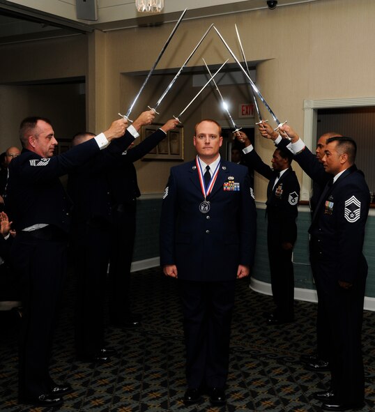 KUNSAN AIR BASE, Republic of Korea -- Tech. Sgt. Patrick Etherson, 8th Maintenance Group, walks through a saber archway during a Senior Noncommissioned Officer Induction Ceremony Aug. 23, 2013. The Wolf Pack had two special guests for this year’s ceremony, Air Force Chief of Staff Gen. Mark A. Welsh III and Chief Master Sgt. of the Air Force James A. Cody, who were visiting Kunsan to thank Airmen for their continued service and dedication. Cody was the guest speaker for the ceremony, and spoke about the significant role SNCOs play in today’s Air Force.  (U.S. Air Force photo by Staff Sgt. Jessica Haas/Released)