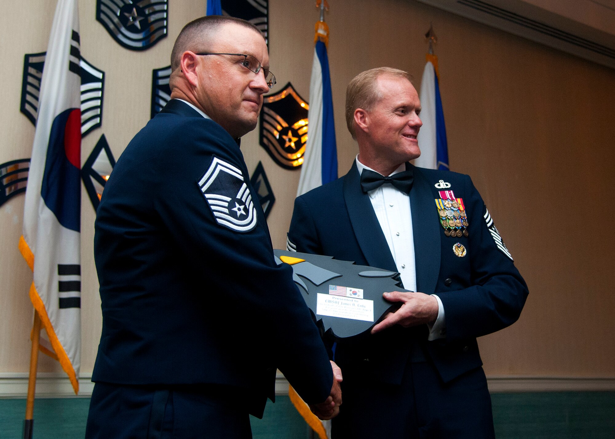 KUNSAN AIR BASE, Republic of Korea -- Chief Master Sgt. of the Air Force James A. Cody receives a plaque from Senior Master Sgt. Michael Smith, 8th Maintenance Squadron, after speaking at the Senior Noncommissioned Officer Induction Ceremony Aug. 23, 2013. Cody, along with Air Force Chief of Staff Gen. Mark A. Welsh III, attended the ceremony while visiting the base to thank Airmen for their continued service and dedication. (U.S. Air Force photo by Staff Sgt. Jessica Haas/Released)