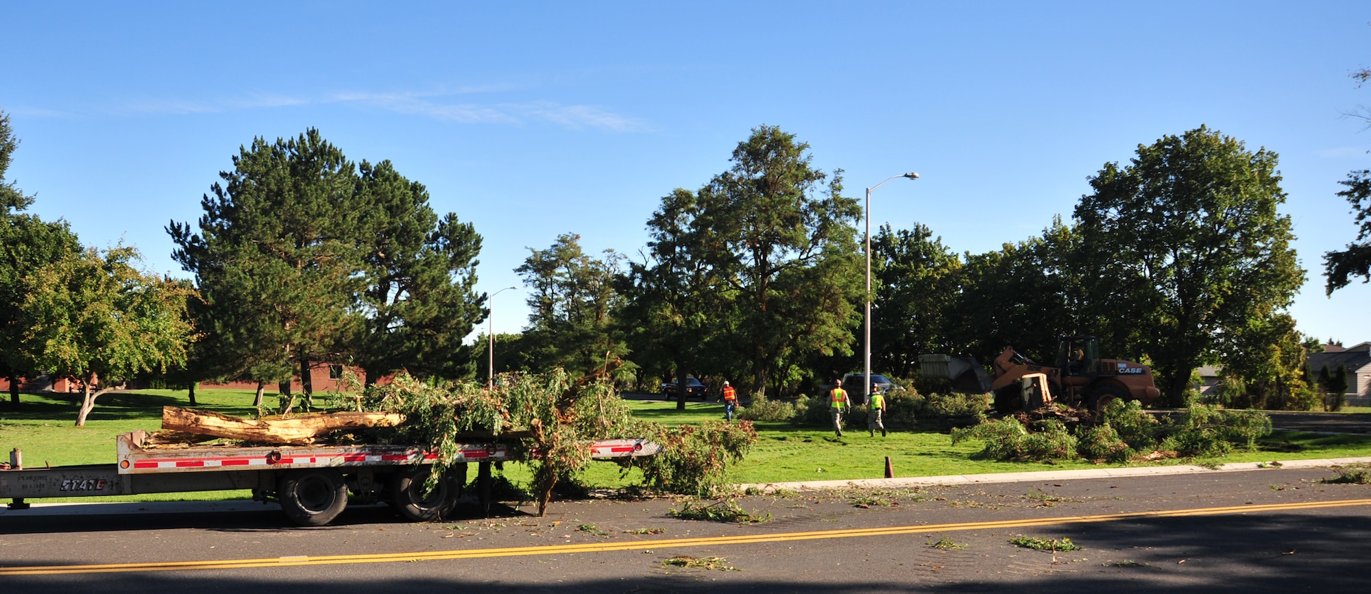 92nd Civil Engineer Squadron heavy repair crews remove fallen trees and large limbs after a severe storm at Fairchild Air Force Base, Wash., Aug. 26. Emergency crews began work immediately following the storm to clear all roads, alert routes and any potential hazards. (U.S. Air Force photo by Staff Sgt. Michael Means/Released)