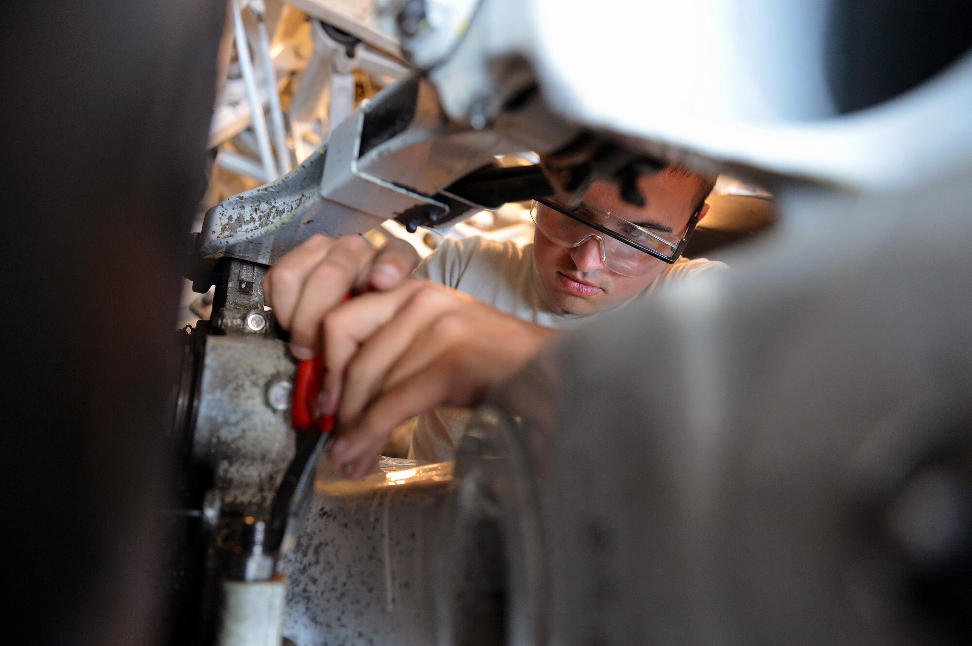 Airman 1st Class Austin Ford-Umfuhrer, 62nd Maintenance Squadron aircraft electrical and environmental specialist, cuts a safety wire from a bolt, Aug. 13, 2013, during an operational check of C-17 Globemaster III aircraft’s braking system, at Joint Base Lewis-McChord, Wash. Electrical and environmental specialists are responsible for inspecting, evaluating and performing maintenance on aircraft cabin pressurization, anti-icing, lighting, warning and fire systems. (U.S. Air Force photo/Airman 1st Class Jacob Jimenez)       