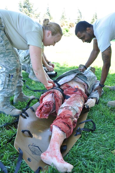 Staff Sgt. Nicole Nagle and Senior Airman Chris Gaiters, both from the 60th Medical Group, train Aug. 22 using the Multiple Amputation Trauma Trainer at David Grant USAF Medical Center. The lifelike dummy even holds the same amount of blood as a human, providing realistic simulation for the hospital's medical staff when it faces real-world situations. (U.S. Air Force photo/Senior Airman Madelyn Brown)