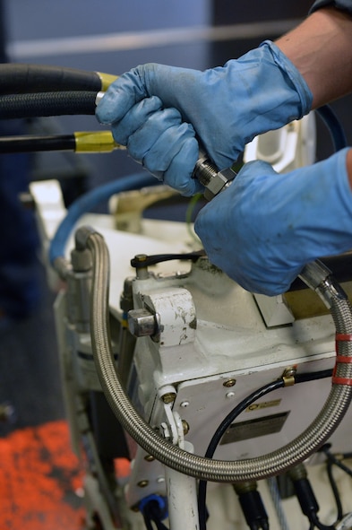 Airman 1st Class Sean Thompson, 62nd Maintenance Squadron hydraulics technician, attaches a hydraulic line to a pump, July 30, 2013, at Joint Base Lewis-McChord, Wash. Hydraulics technicians regularly inspect and perform maintenance on hydraulic support equipment used on McChord’s C-17 Globemaster III aircraft. (U.S. Air Force photo/Airman 1st Class Jacob Jimenez) 